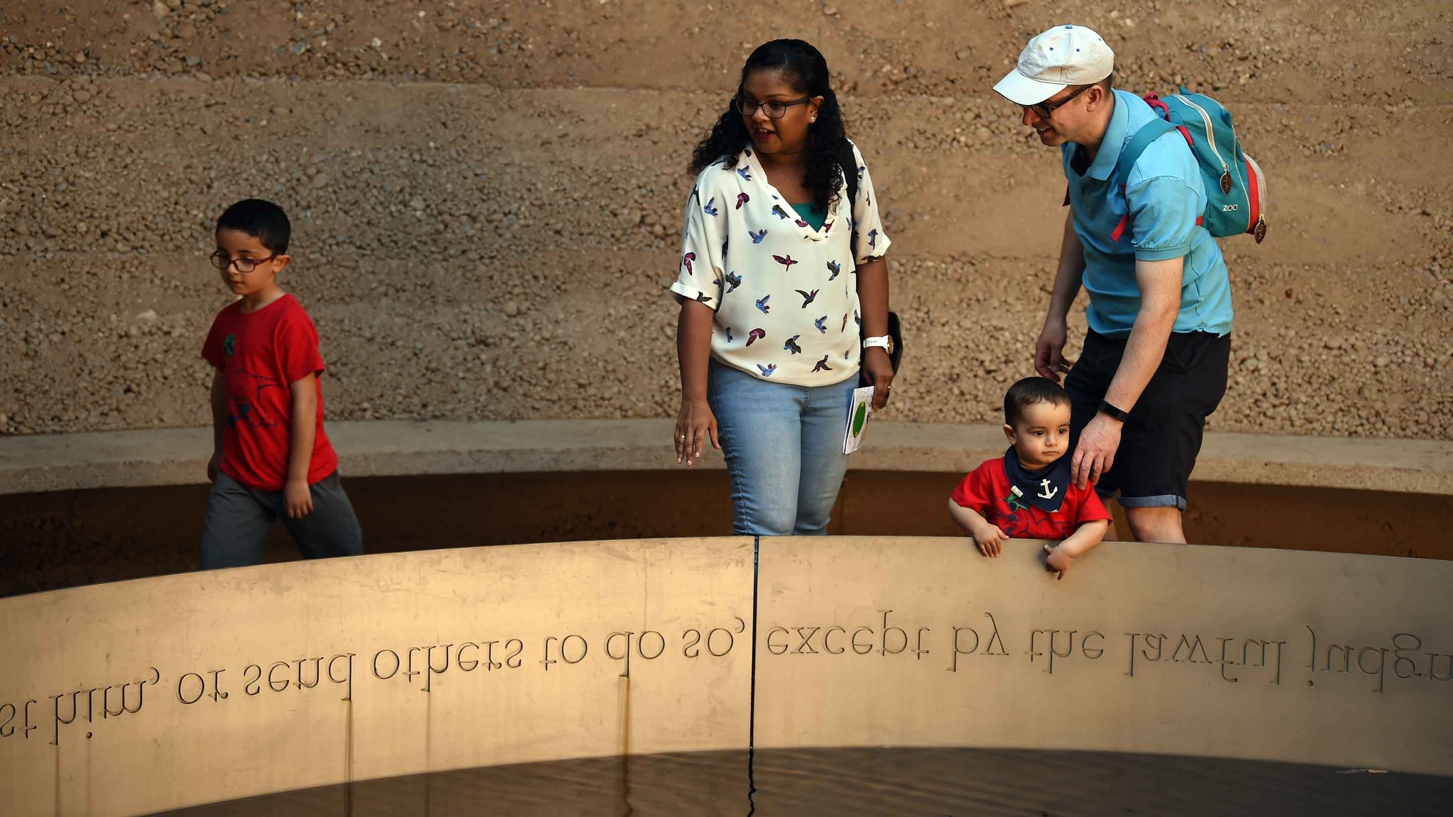 Visitors explore the Writ in Water architectural artwork which features words from the Magna Carta carved in stone
