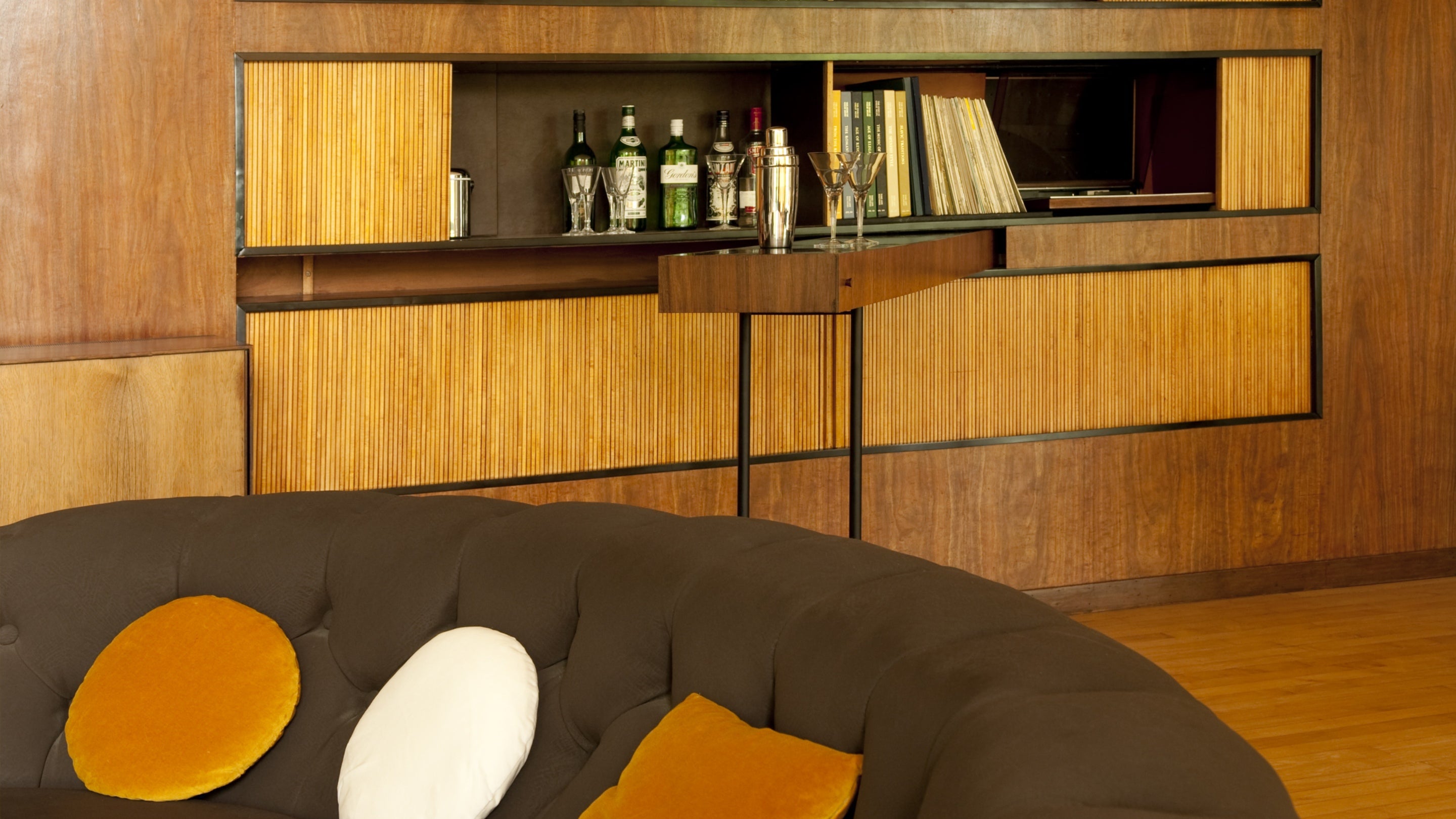 Indian laurel wall units with the curved sofa in front, in the Living Room at The Homewood, Surrey