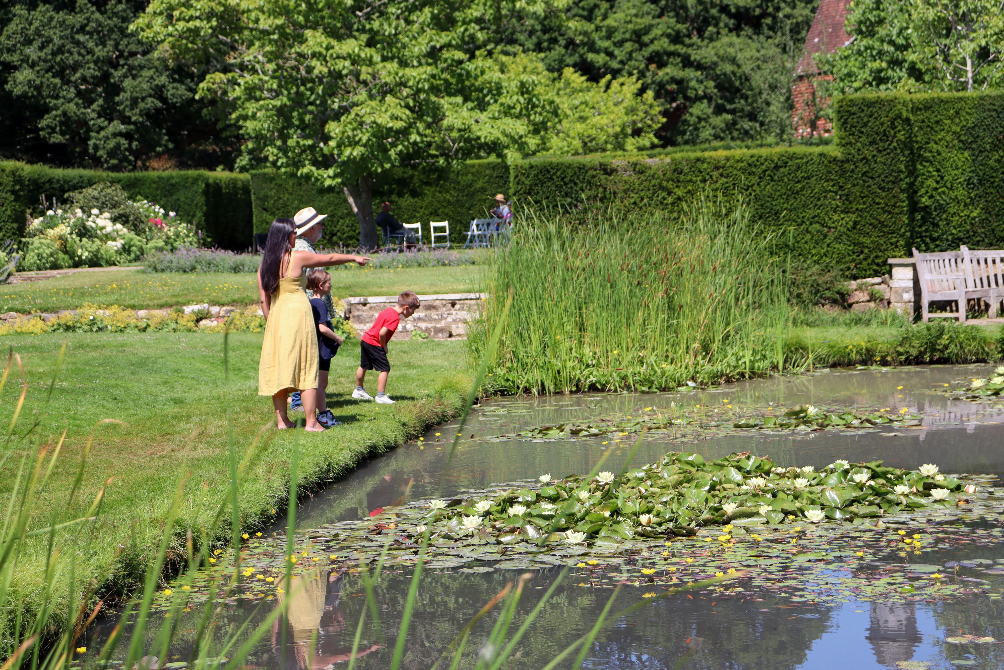 A group of people standing by the lily pond at Bateman's
