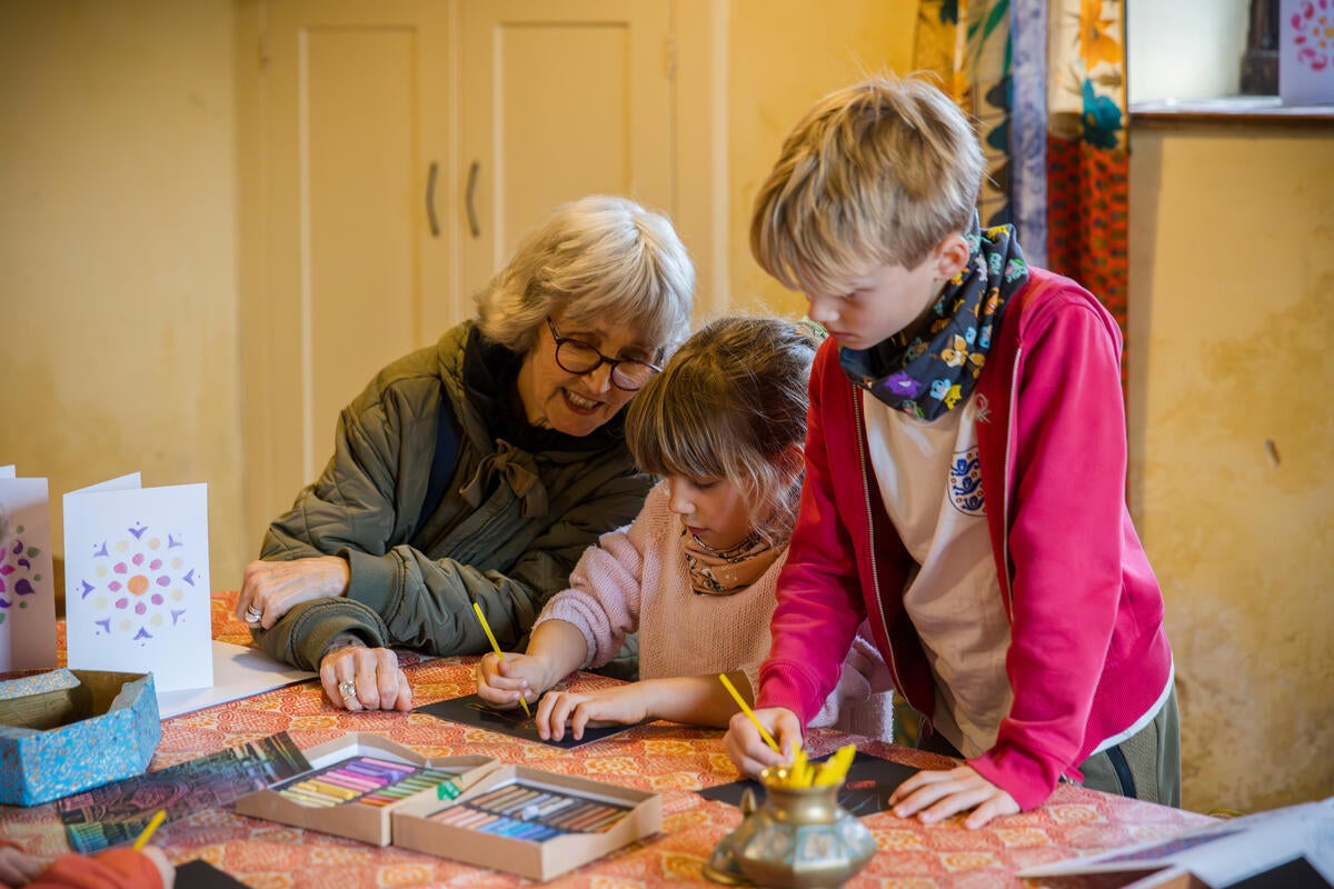 Families sitting at a table doing craft activities