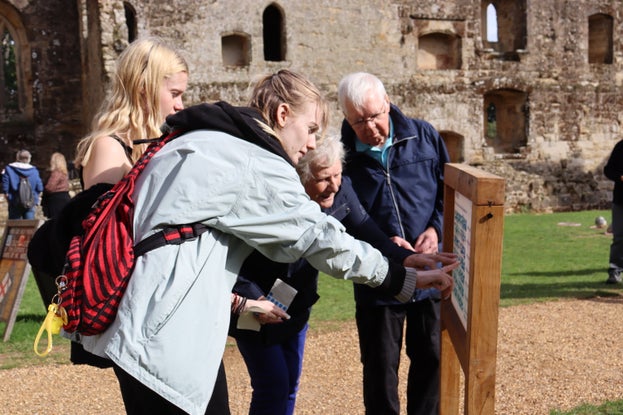 Visitors sticking stickers on a boards to vote for their favourite designs