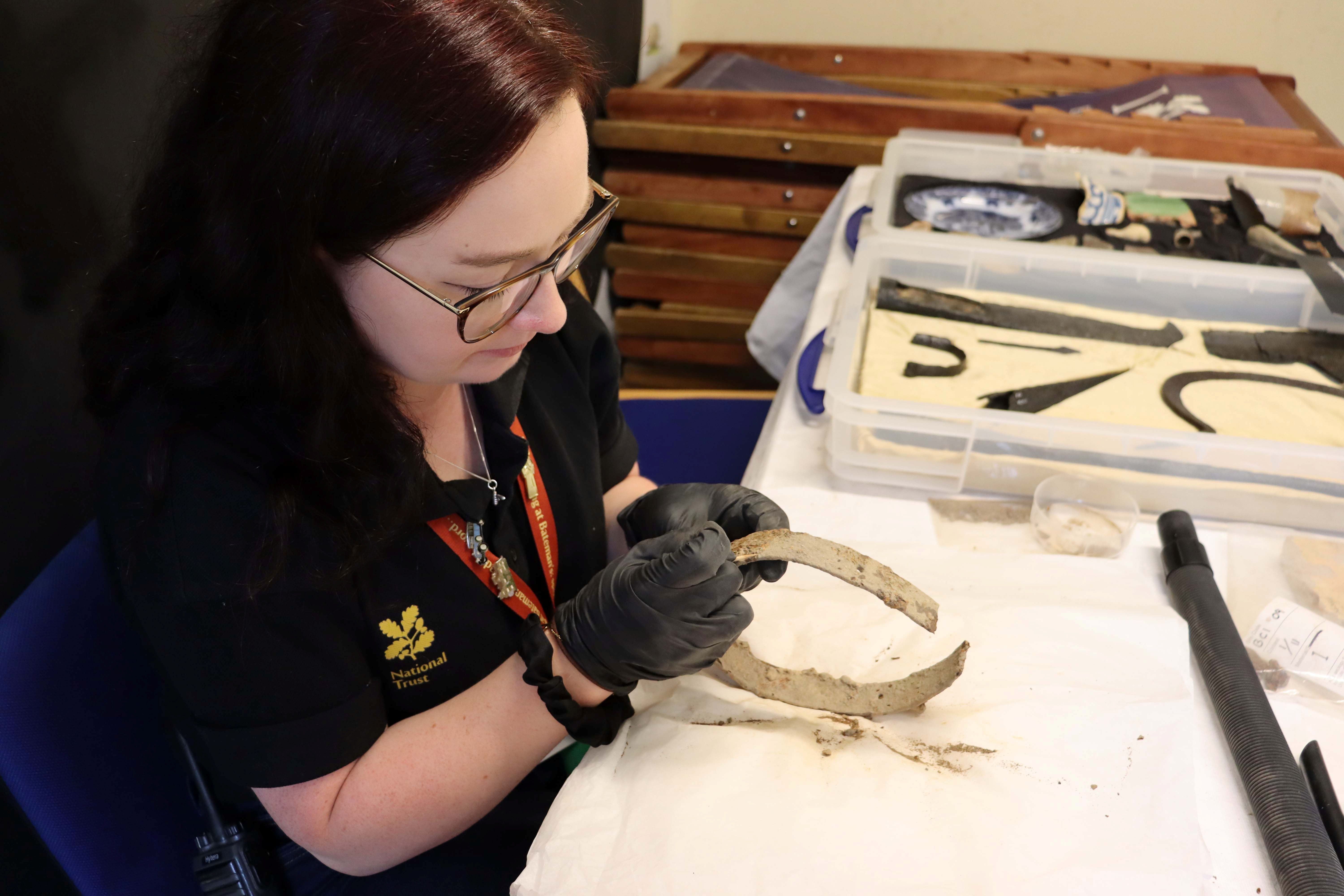 Person cleaning an object from the Bodiam Castle collection