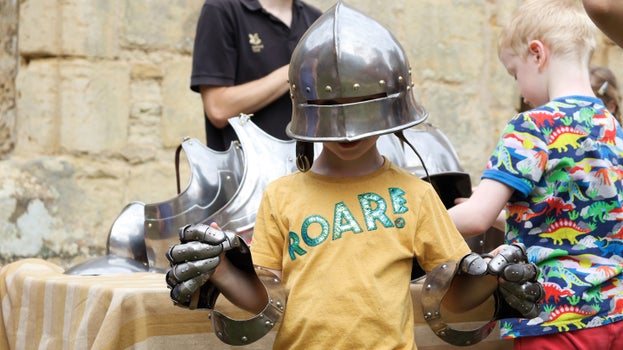 Child trying on replica medieval armour