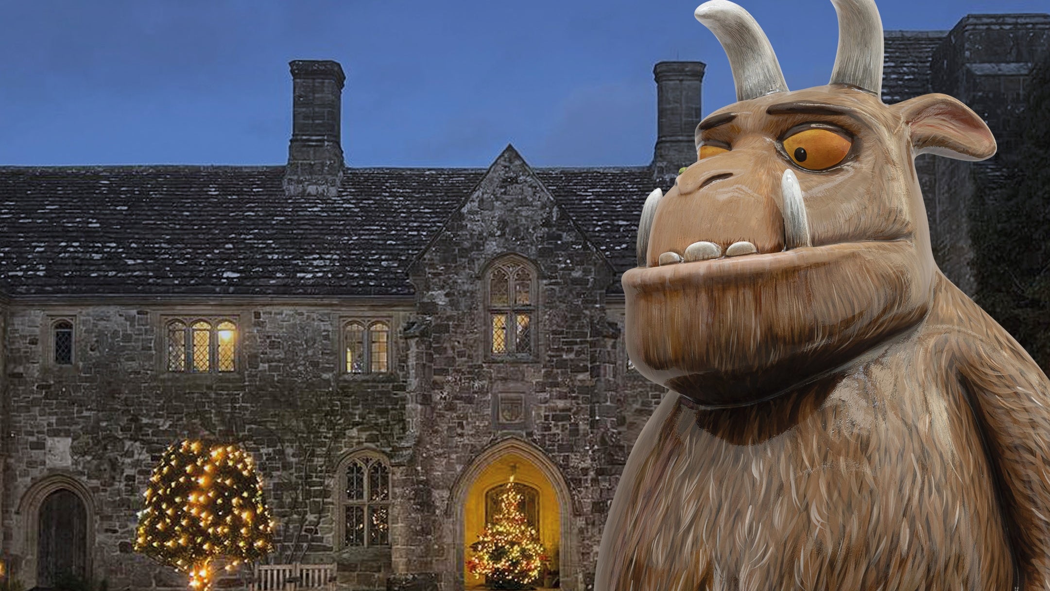 The Gruffalo figurine standing in front of Nymans at night.