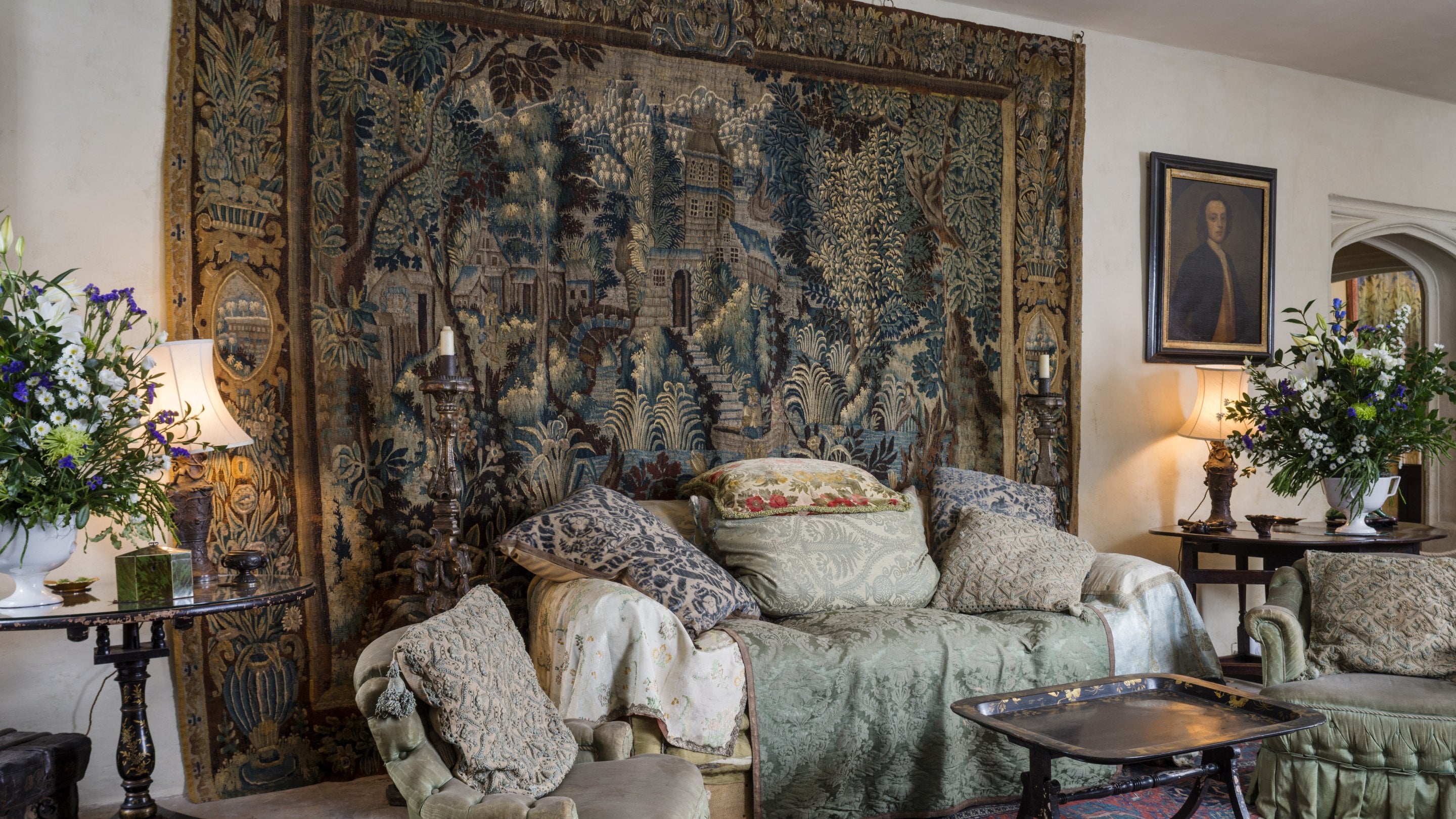 View of the sofa, chairs and wall tapestry in the Garden Hall, Nymans, West Sussex.