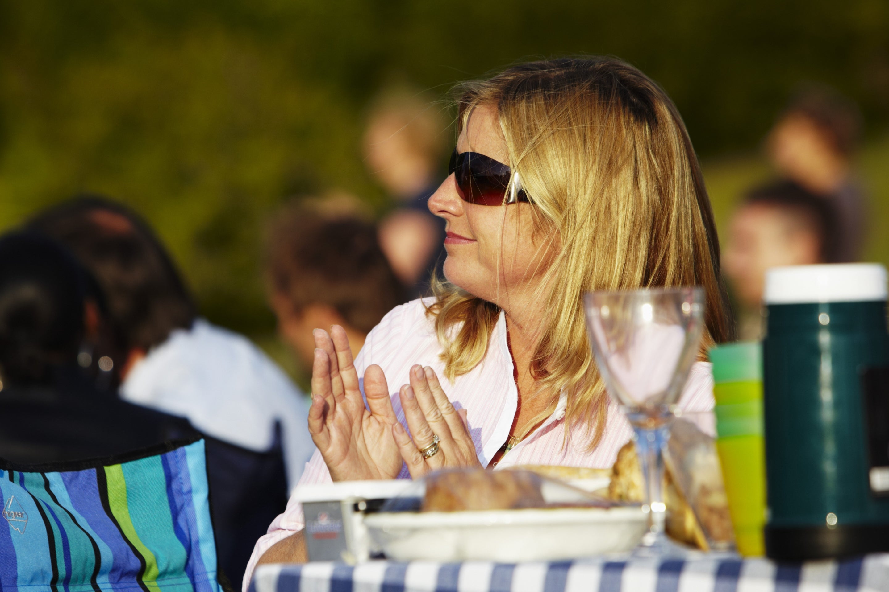 Seated woman clapping and enjoying a picnic