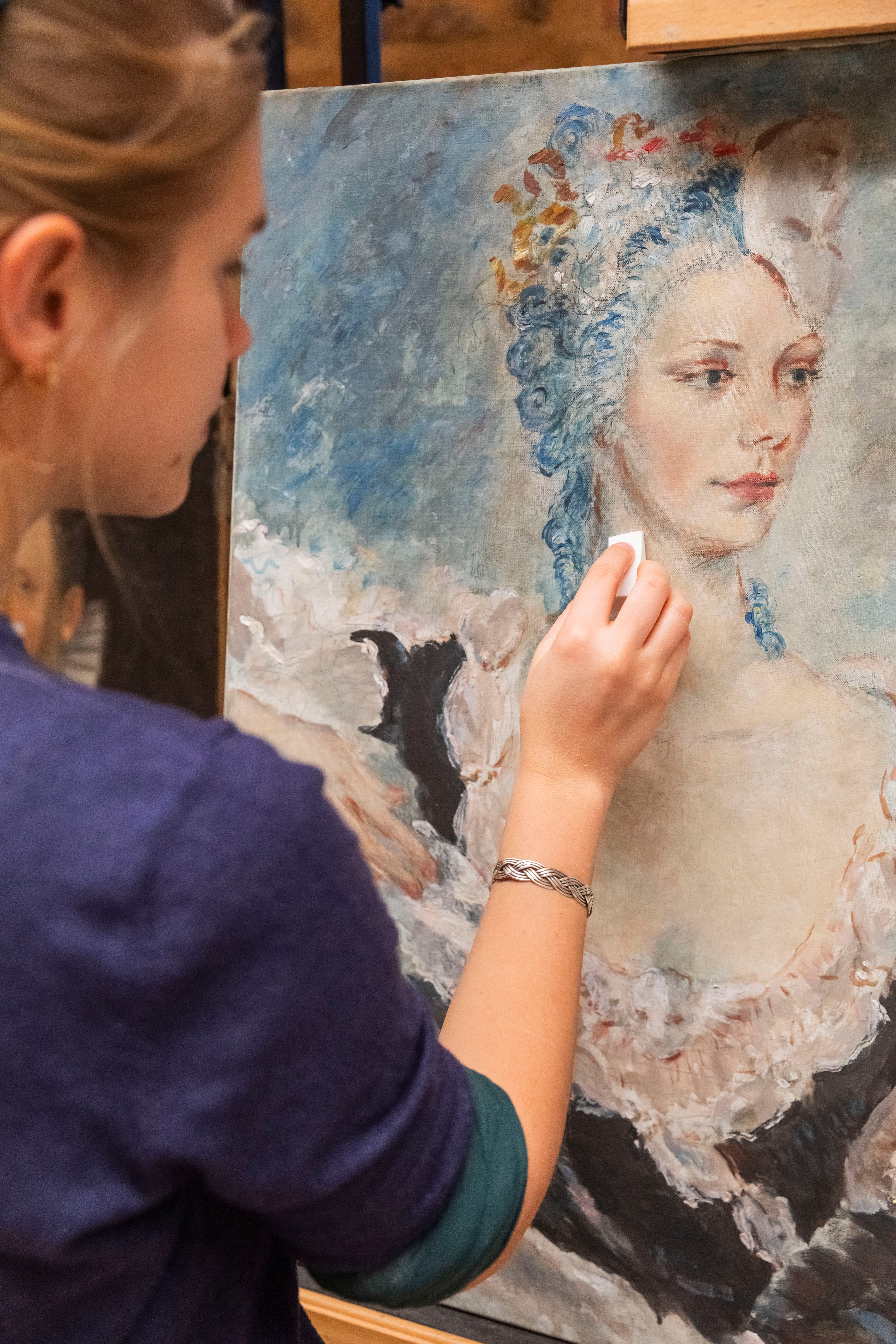 Conservator working on a portrait by Oliver Messel