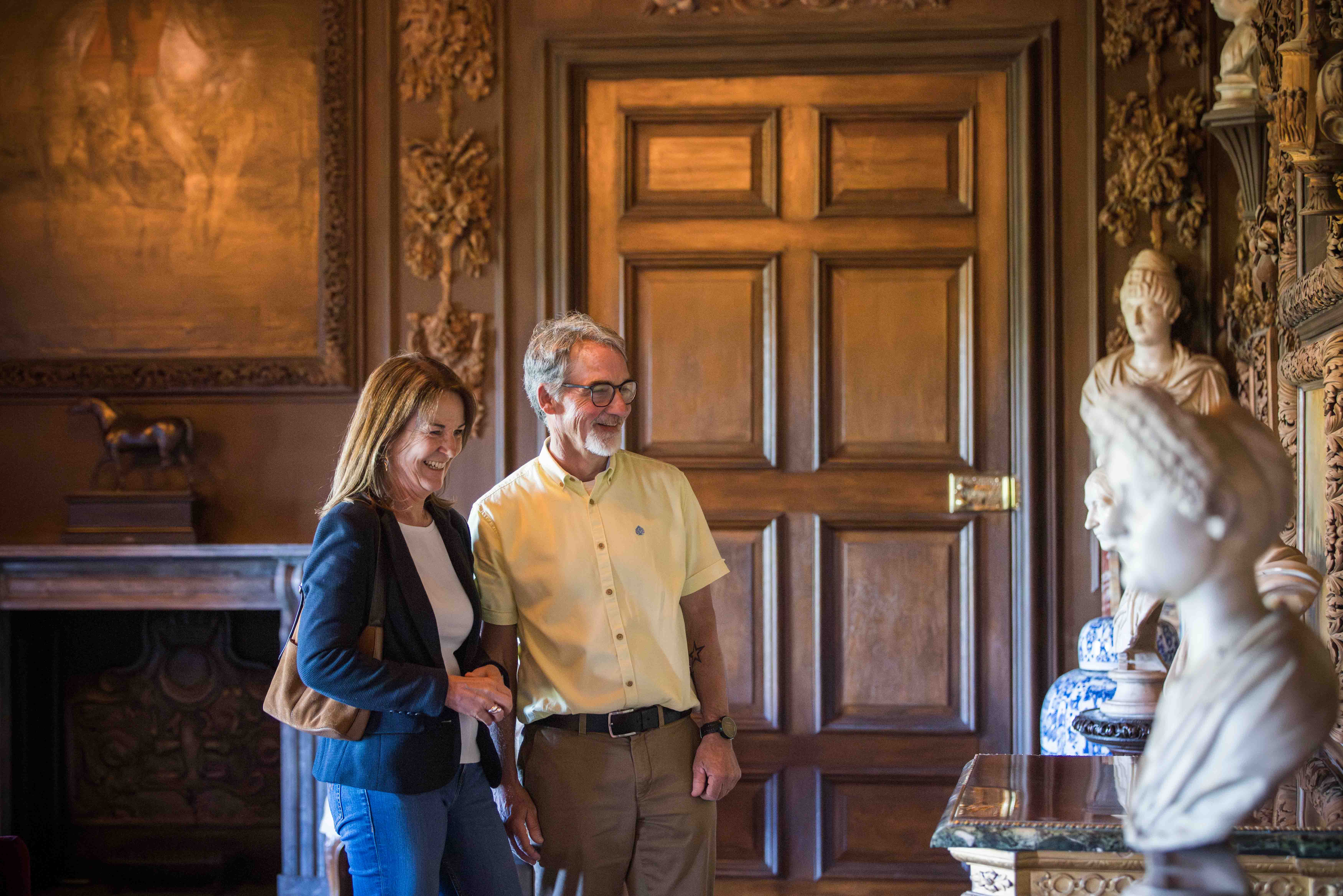 Visitors exploring the Carved Room in Petworth House
