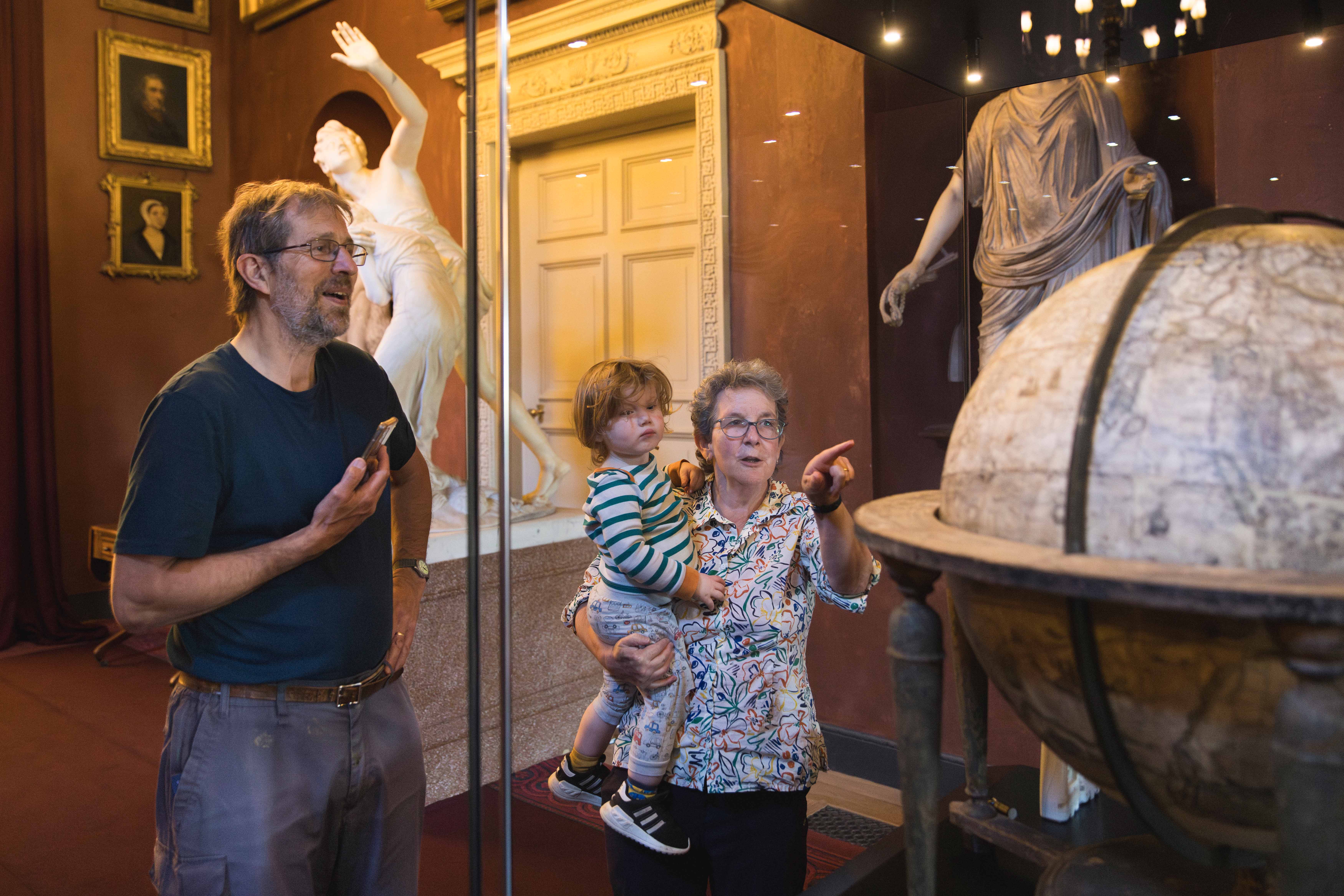 Visitors viewing the Molyneux Globe in the North Gallery at Petworth