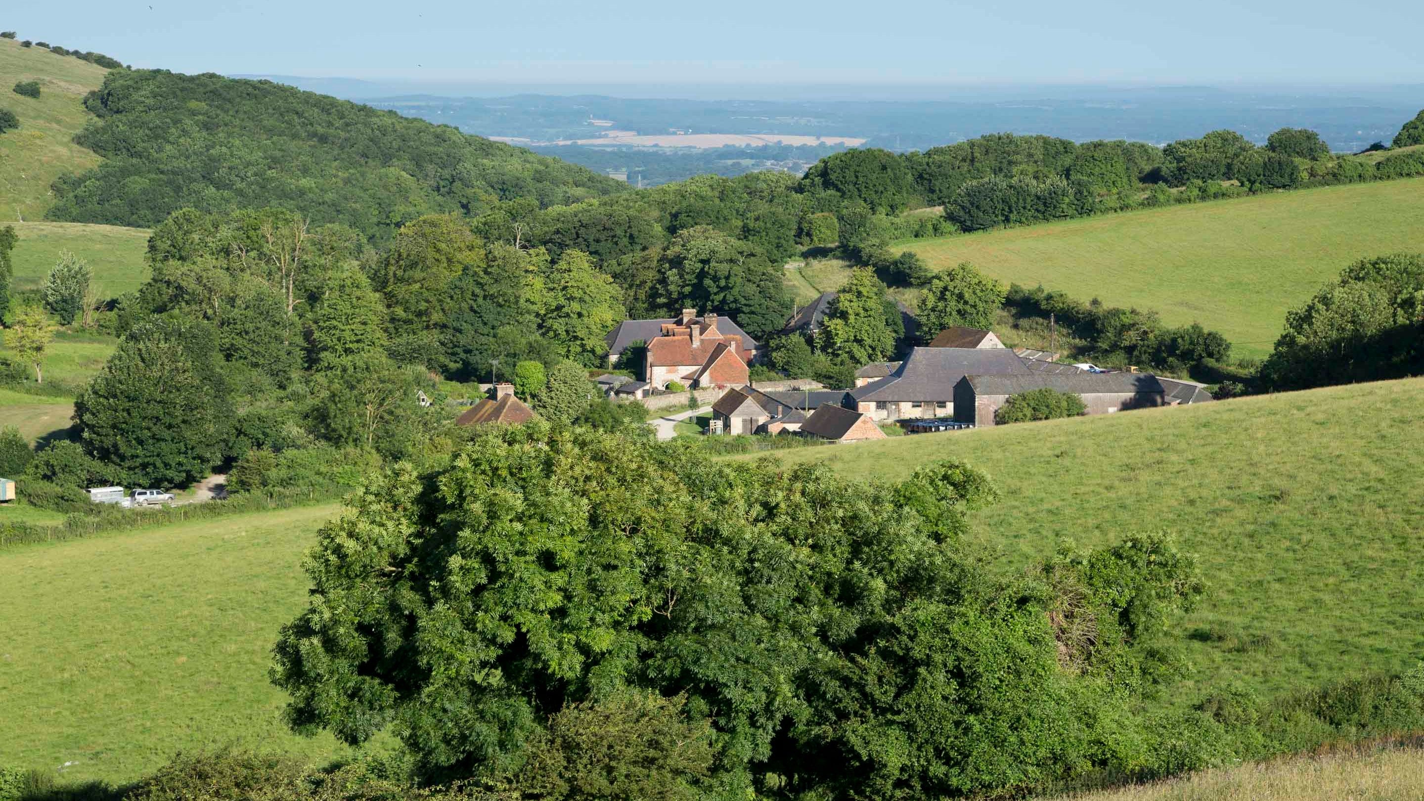 The farm, set amid trees, at Saddlescombe Farm and Newtimber Hill, West Sussex