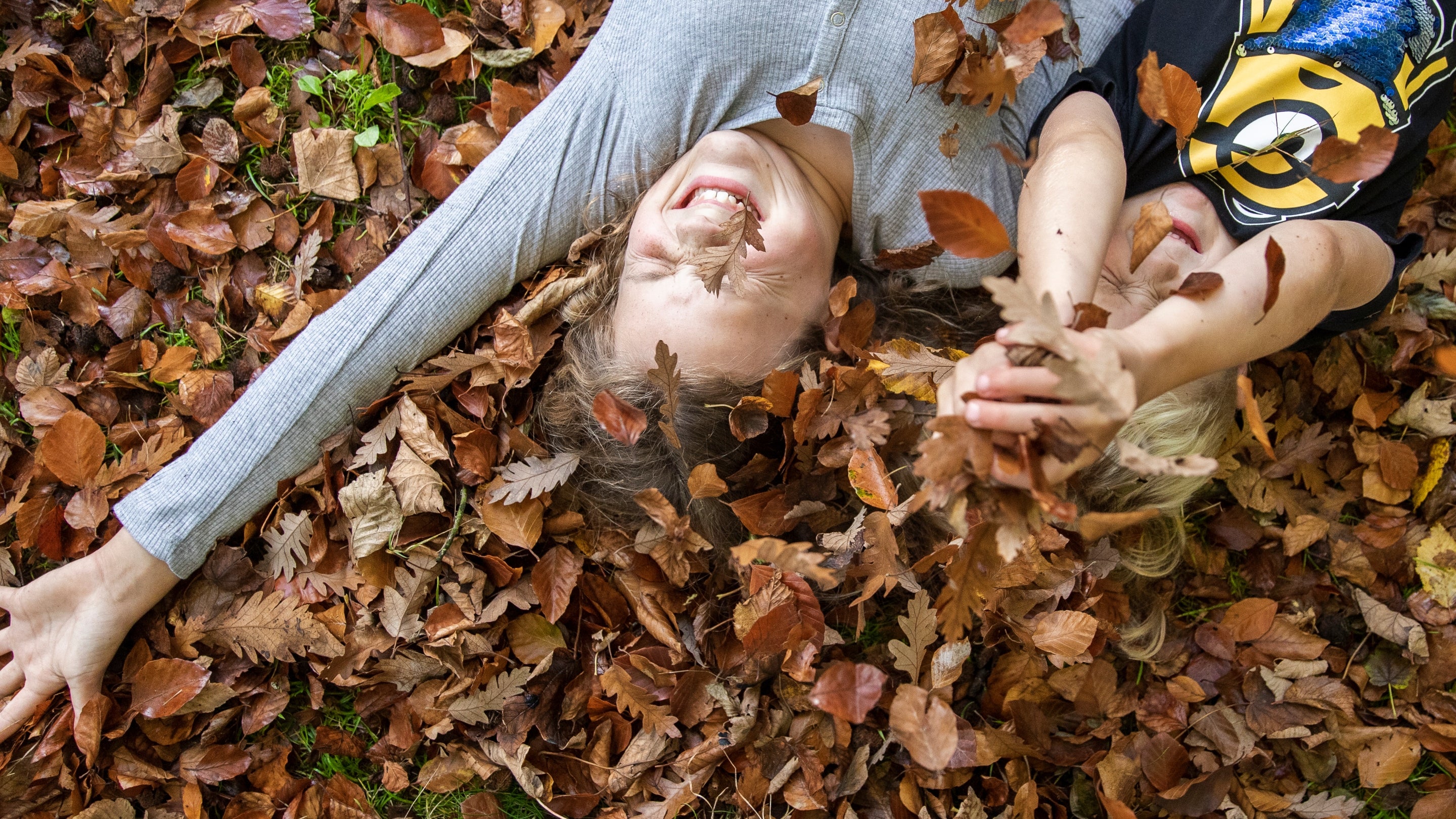 Children playing the the autumn leaves