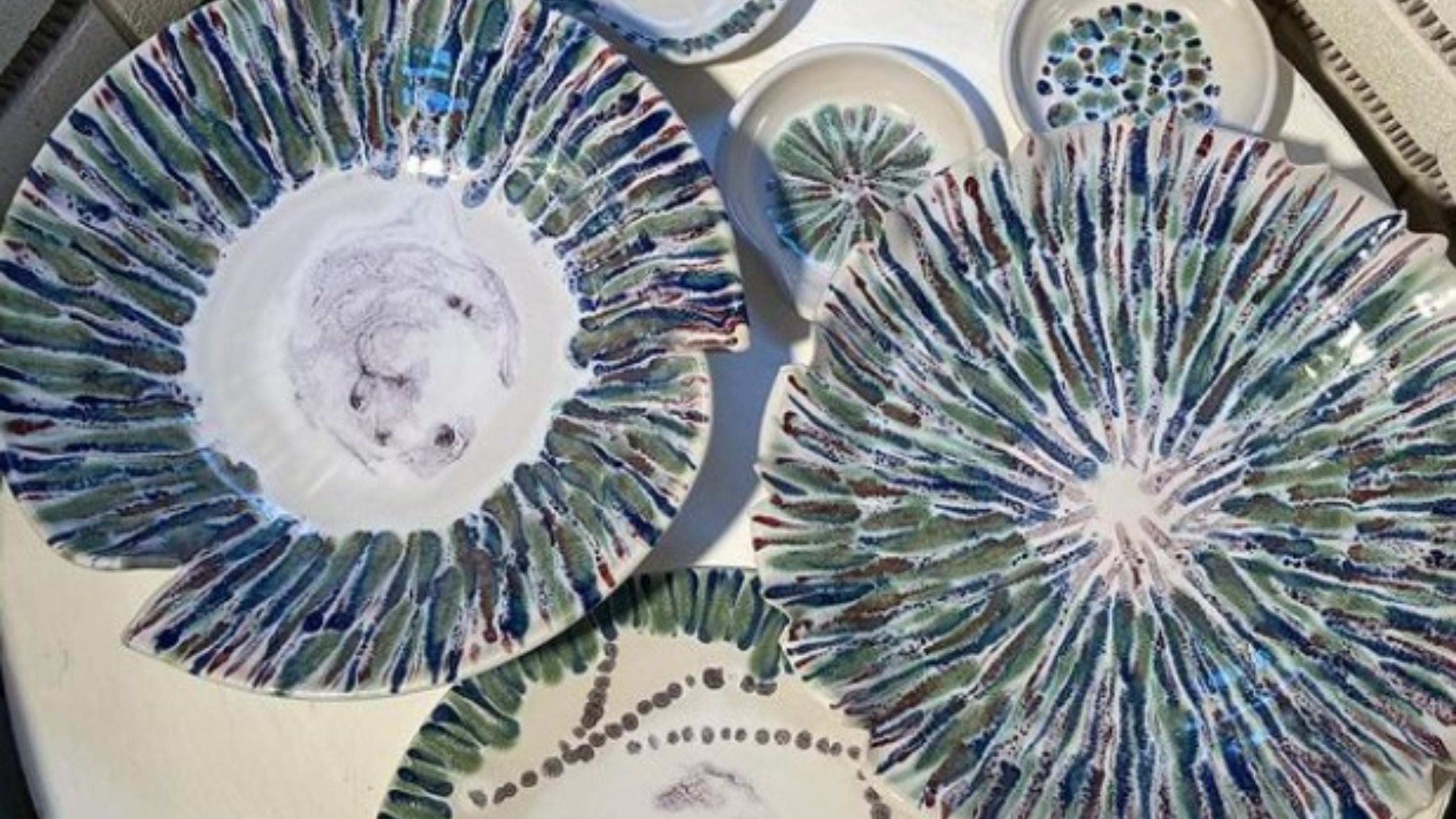 Blue, white and green stripy plates seen from above and created by Peter Curtis, Millbrook Pottery