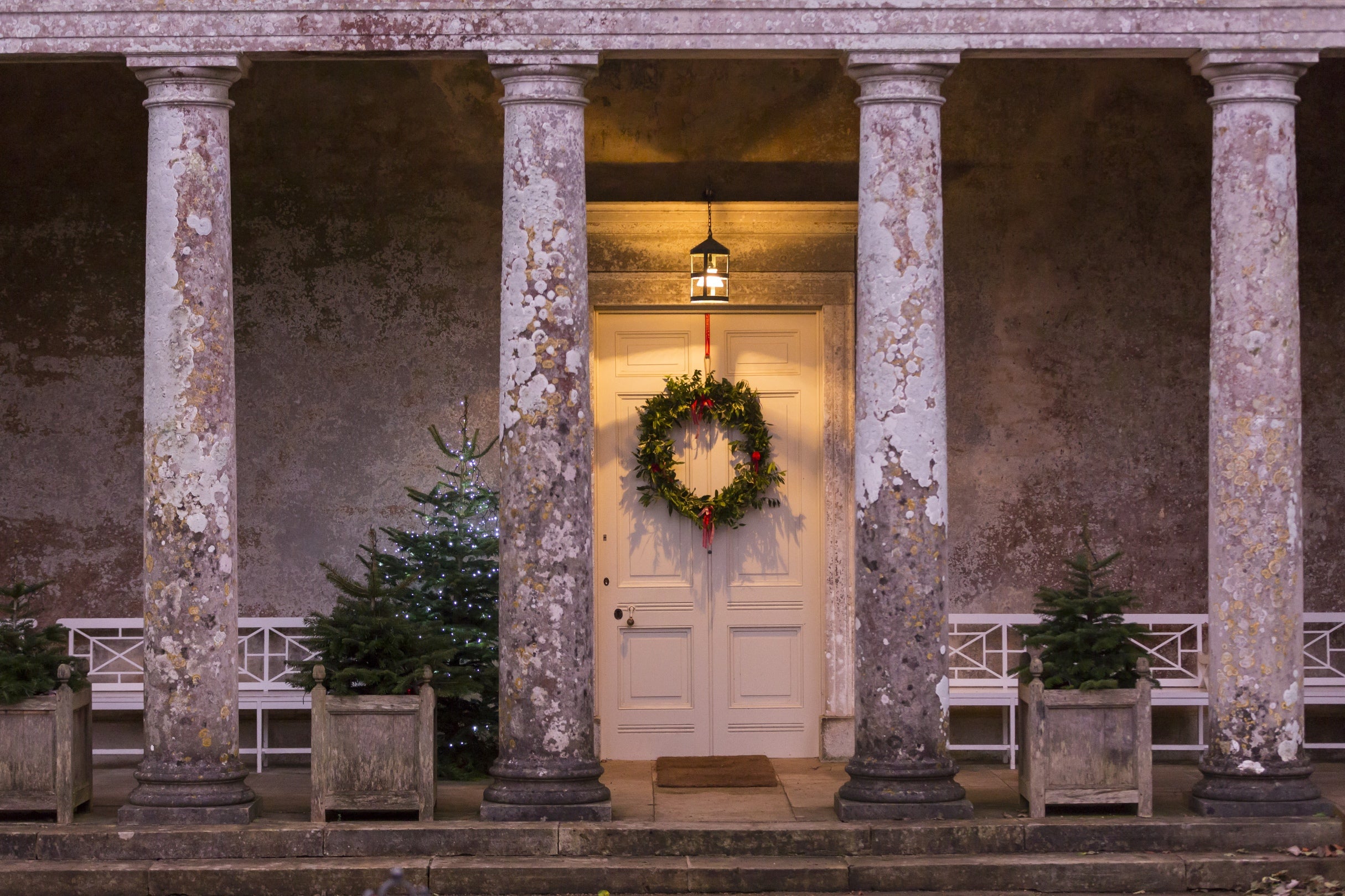 Portico entrance at Uppark decorated with wreath and Christmas trees for Christmas, West Sussex