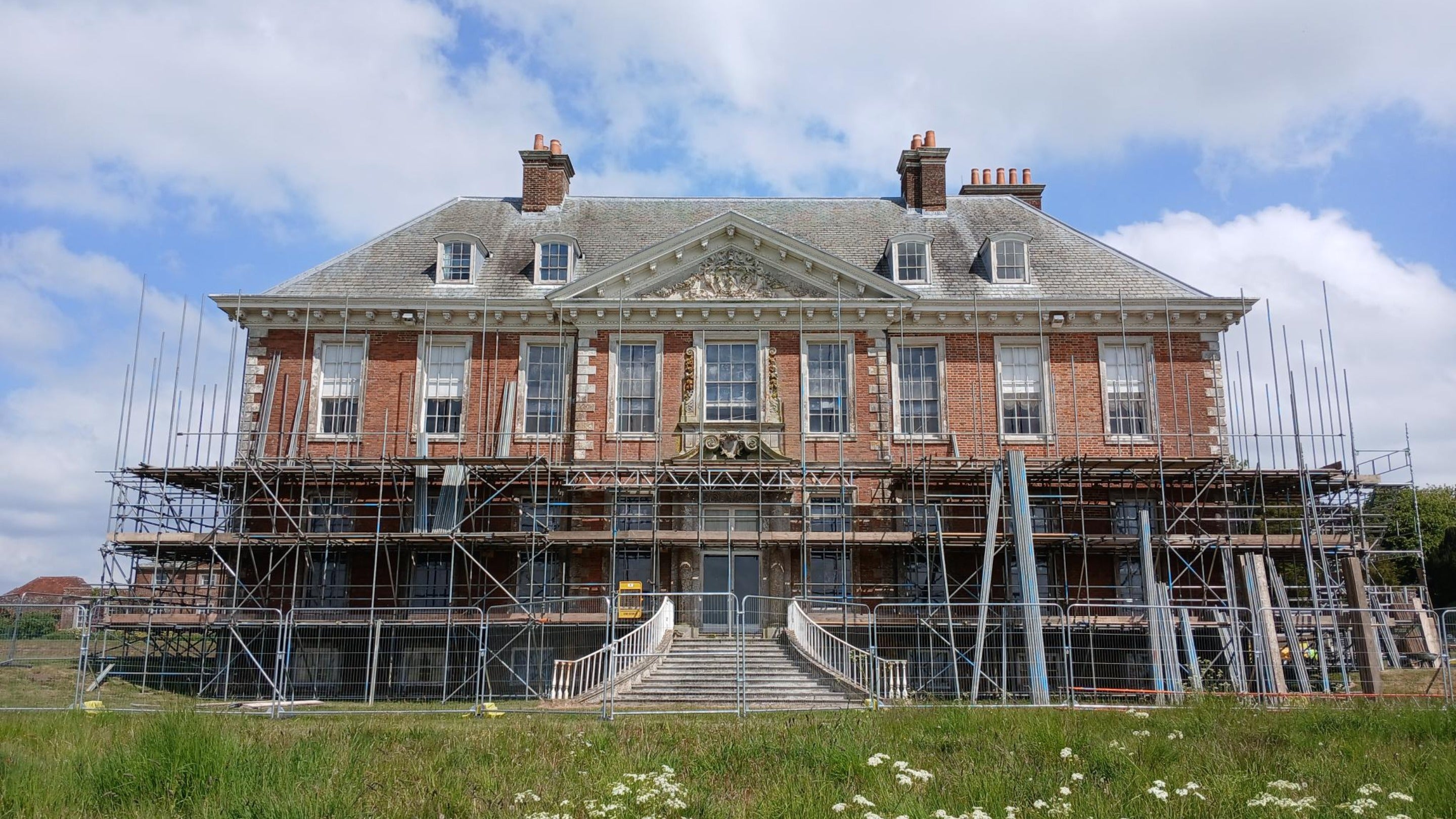 One face of a brick mansion house with scaffolding erected against it