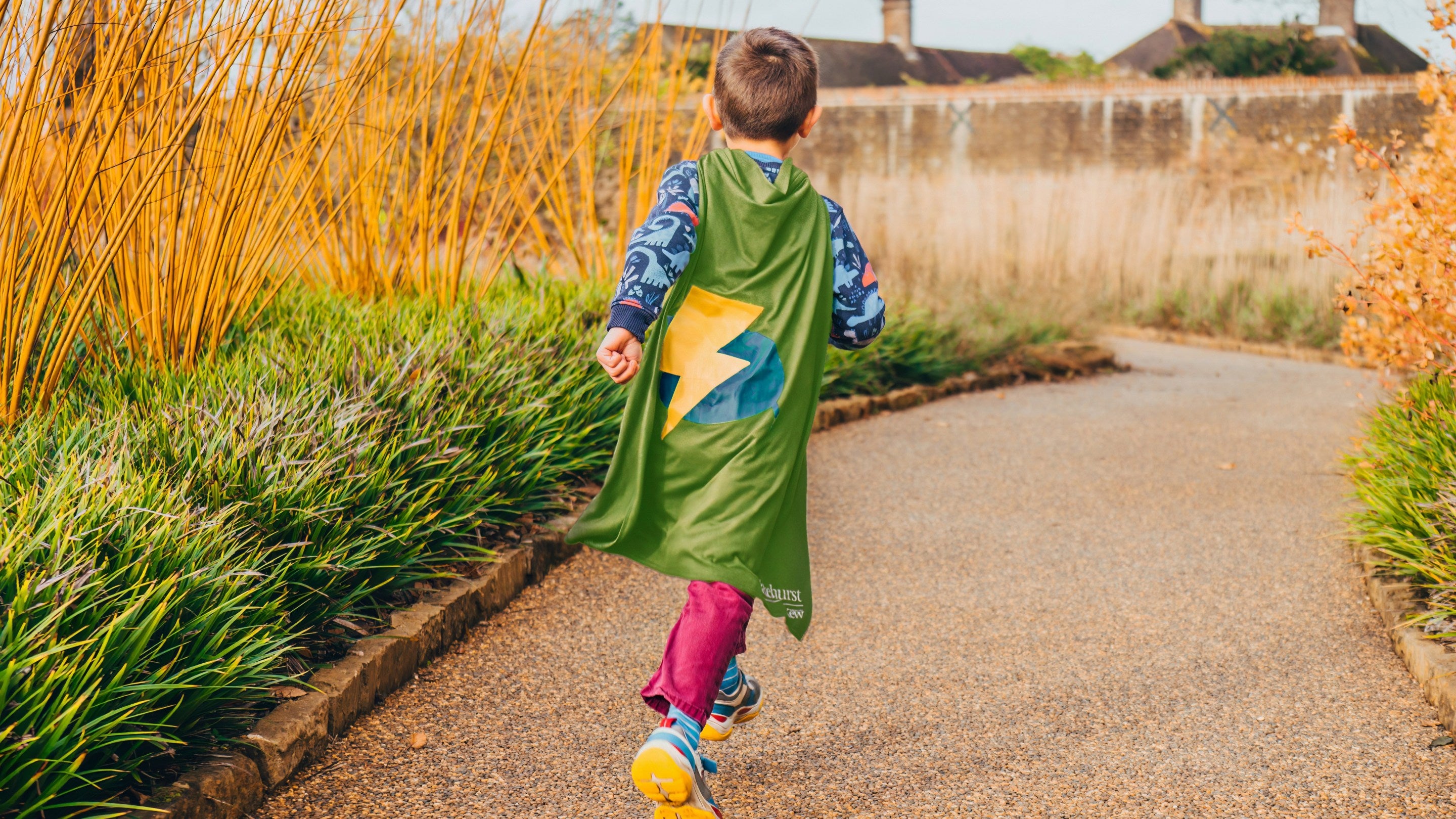 Child wearing cape taking part in Nature Hero actvity at Wakehurst.