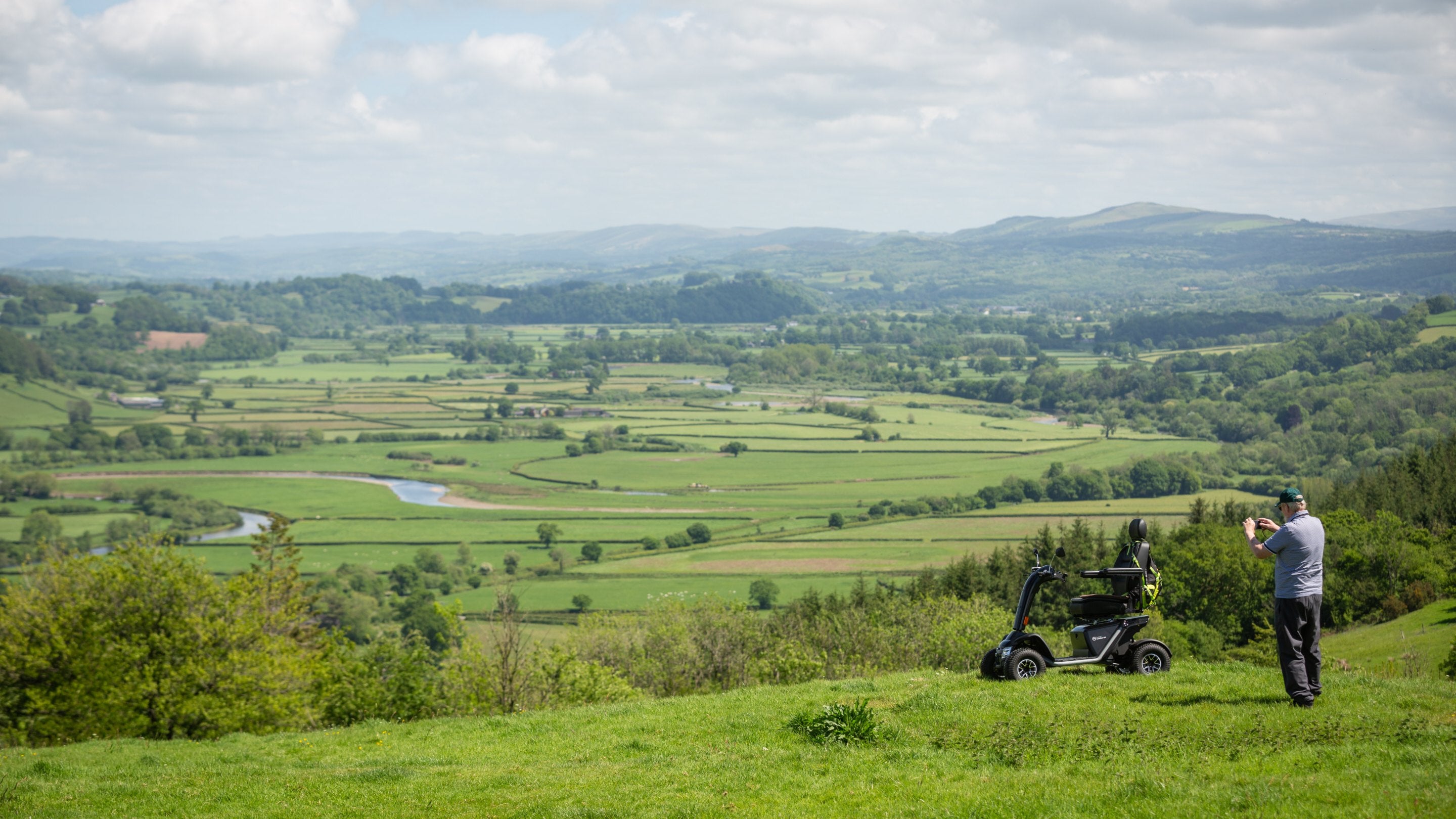 A visitor taking a picture of the Tywi Valley from the hill which Paxton's Tower stands on, Carmarthenshire