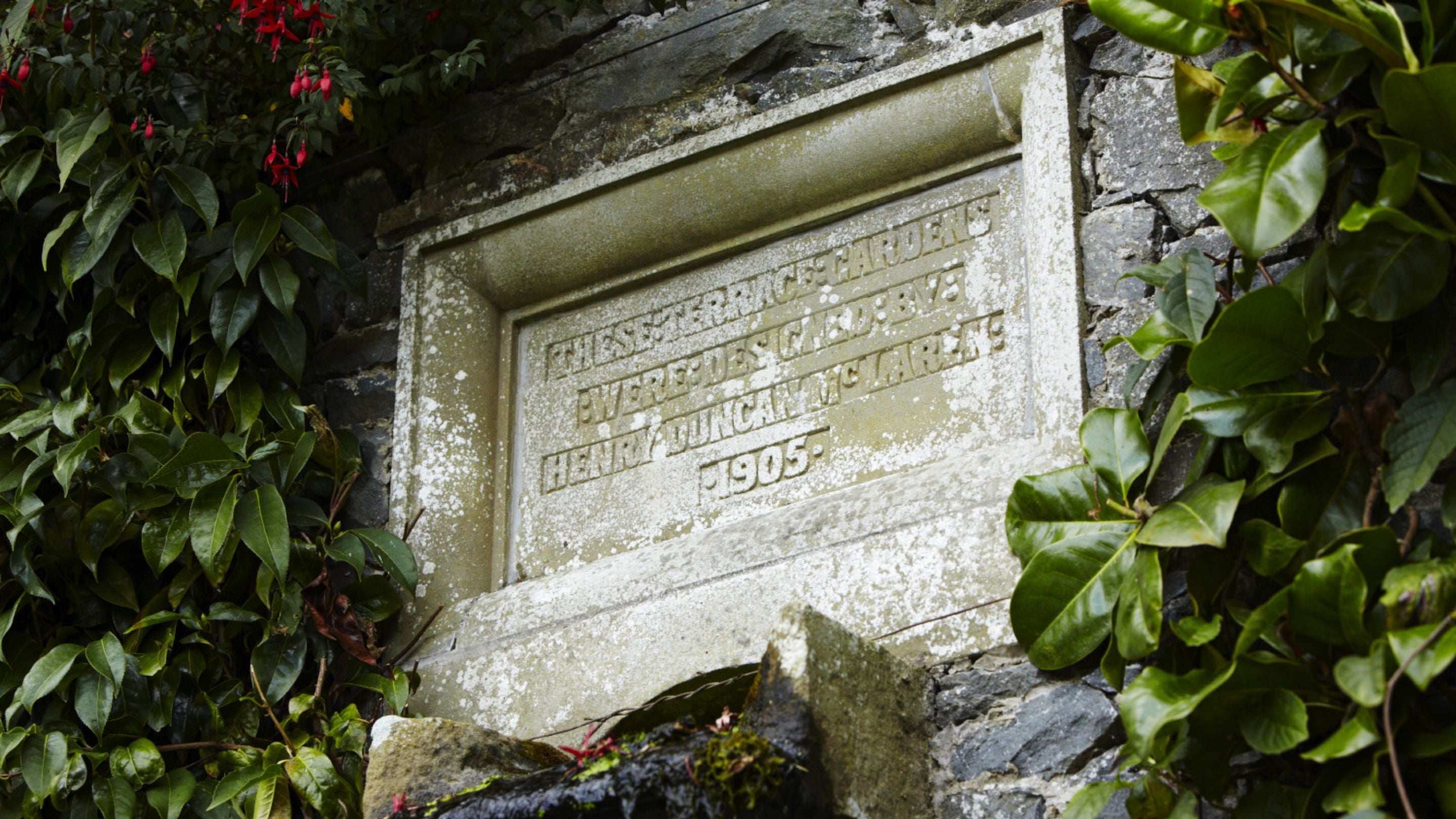 Engraved tablet commemorating the designer of the terrace gardens, Henry Duncan McLaren, above the fountain on the Canal Terrace at Bodnant Garden, Conwy, Wales.