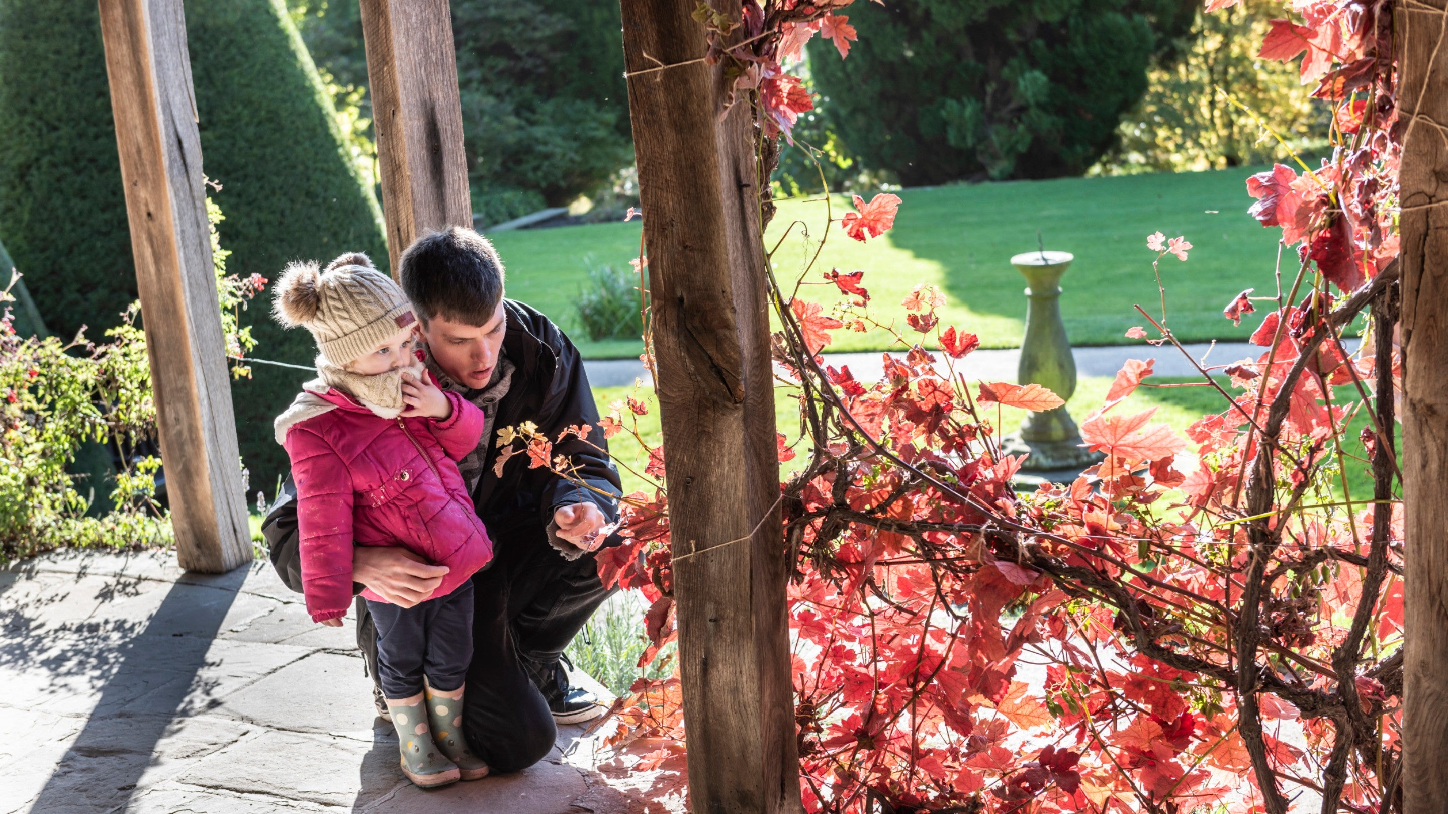 A family exploring the autumn colours in the garden at Chirk Castle and Garden, Wrexham.