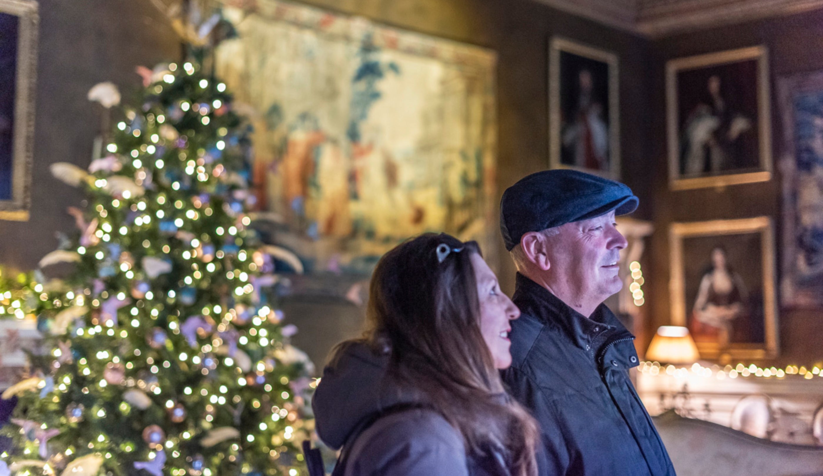 A couple admire the saloon decorated for Christmas at Chirk Castle