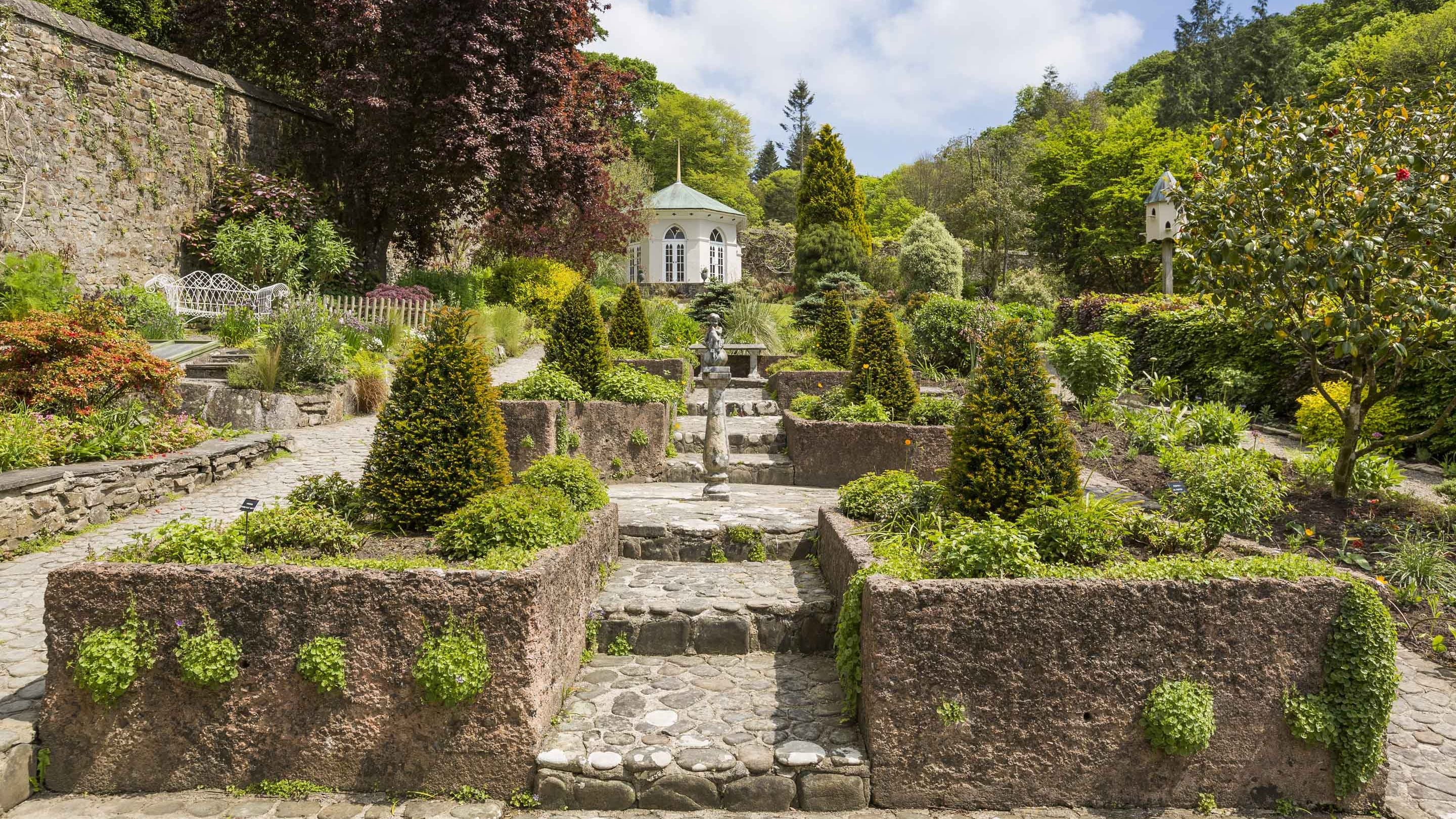 The Walled Garden with cobbled paths, summer house, trees and plants at Colby Woodland Garden, Pembrokeshire