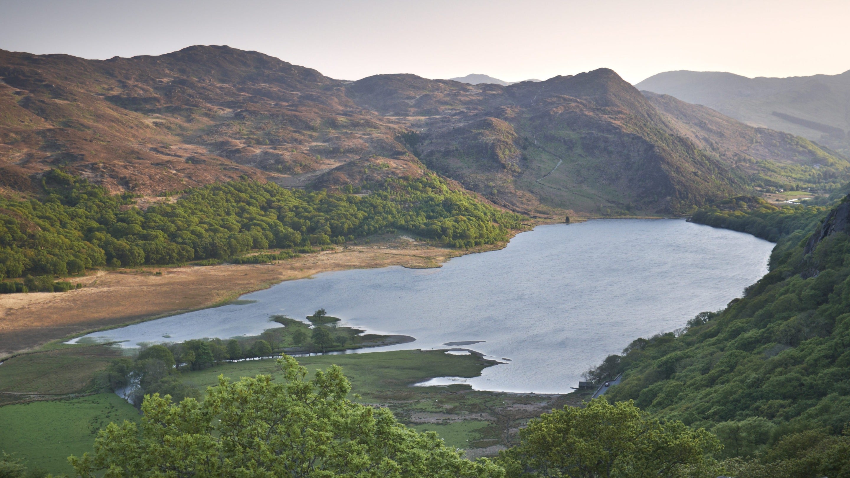 View of the landscape at Llyndy Isaf farm in the Nant Gwynant valley, with mountains, woodland and lake, Snowdonia, Wales.