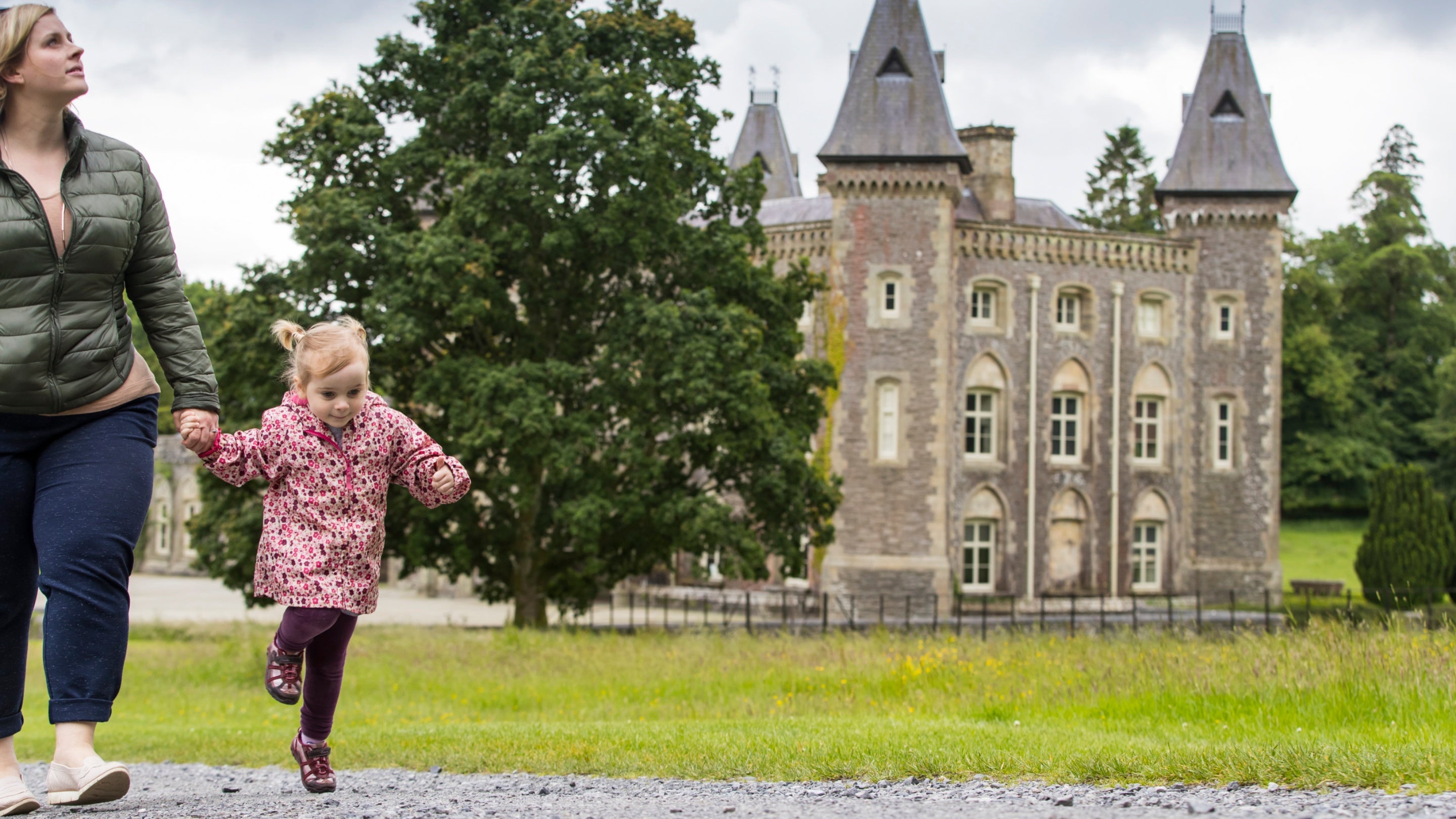 Mother and daughter exploring the estate at Dinefwr, Carmarthenshire, with Newton House behind.