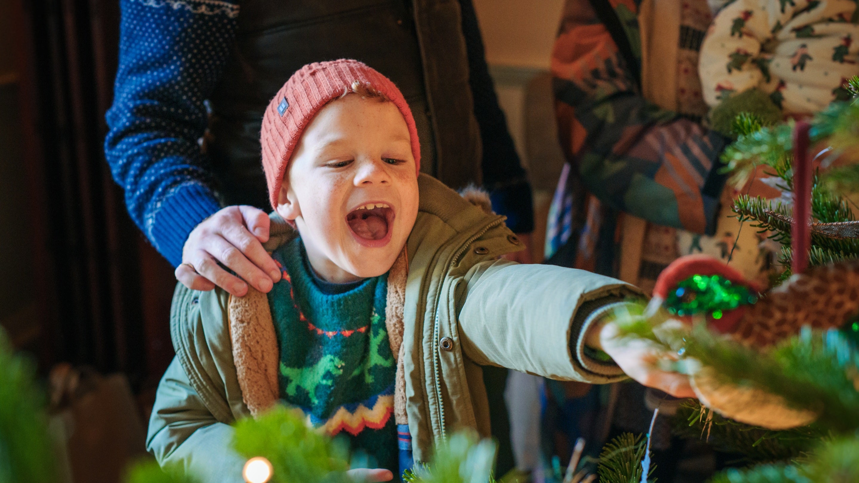 A child excited to spot a special decoration on the Creatures of Dinefwr Christmas Tree, Dinefwr, Carmarthenshire