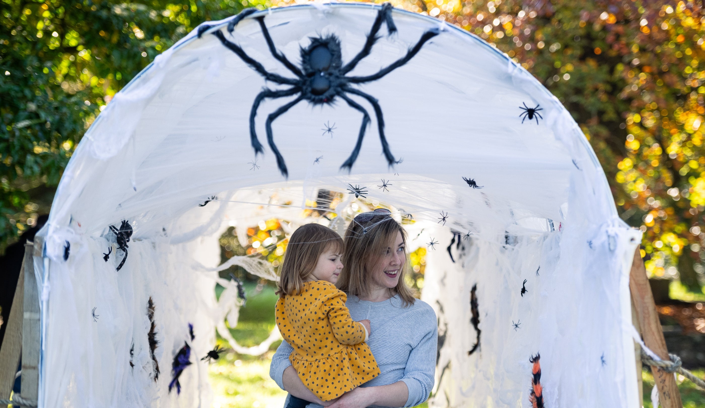A mother and child in a spooky spider tunnel at Dyffryn Gardens, Glamorgan