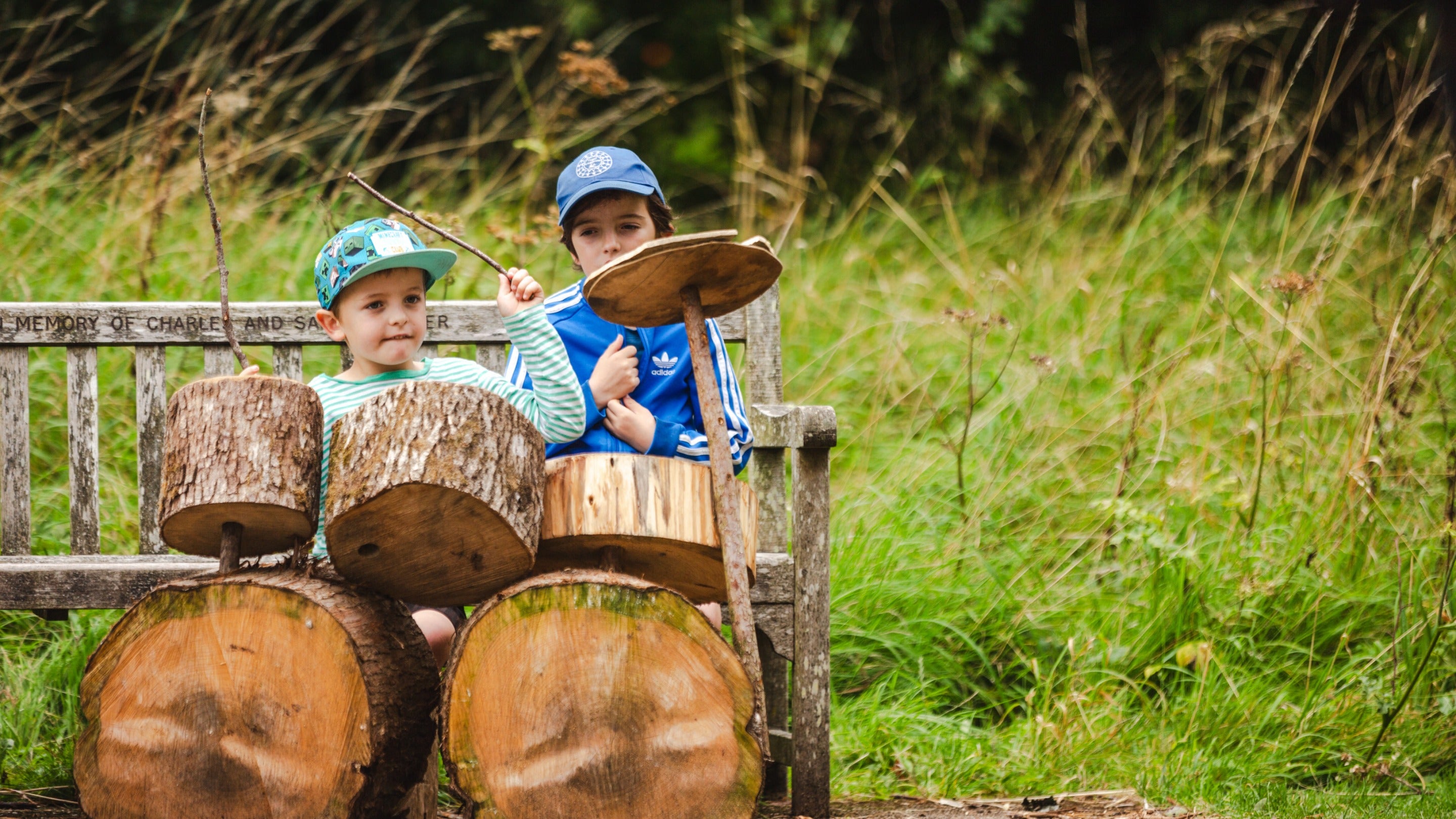 Children play natural instruments in the log stack at Dyffryn Gardens, Vale of Glamorgan