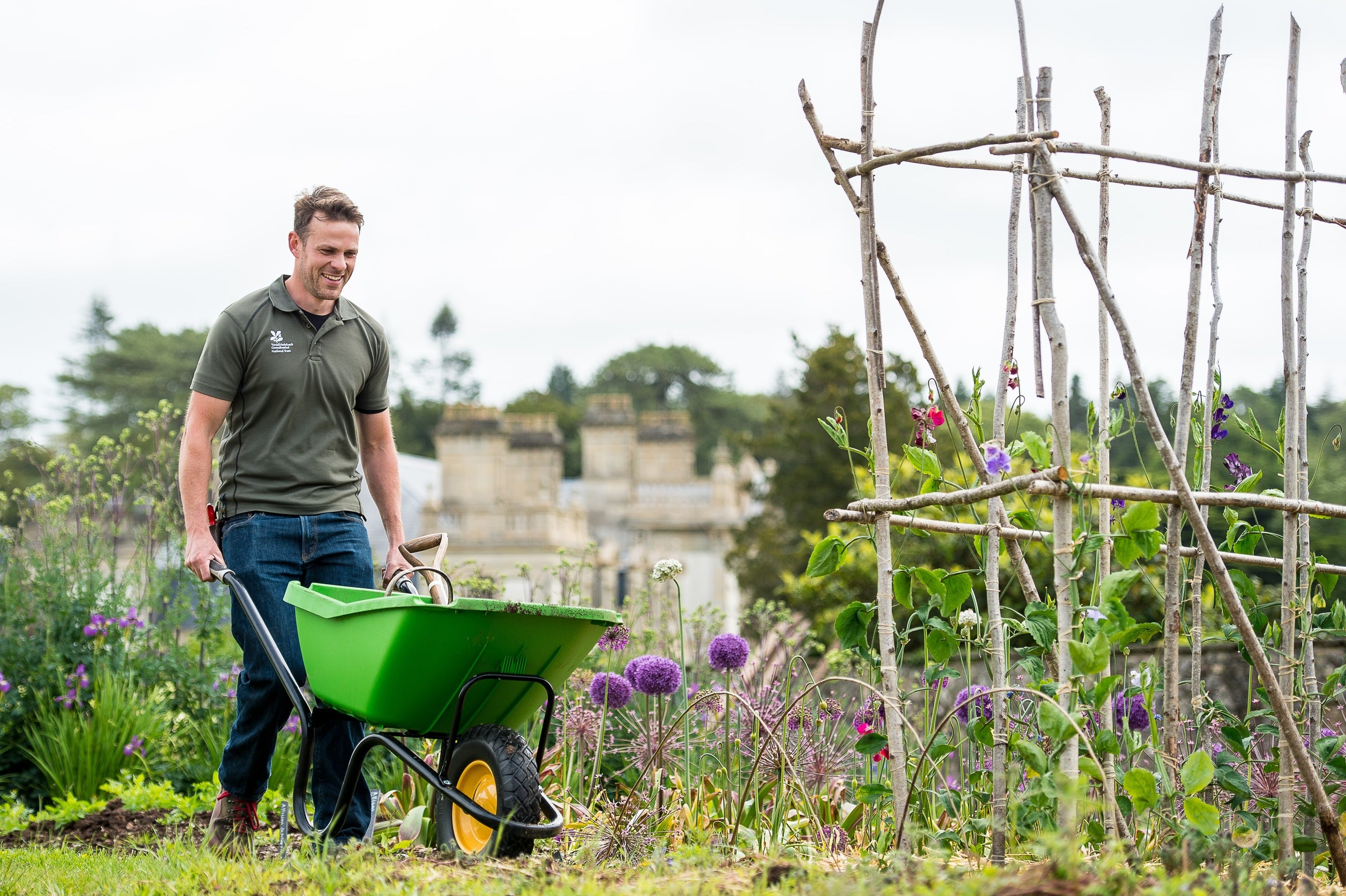Gardener with wheelbarrow in a garden