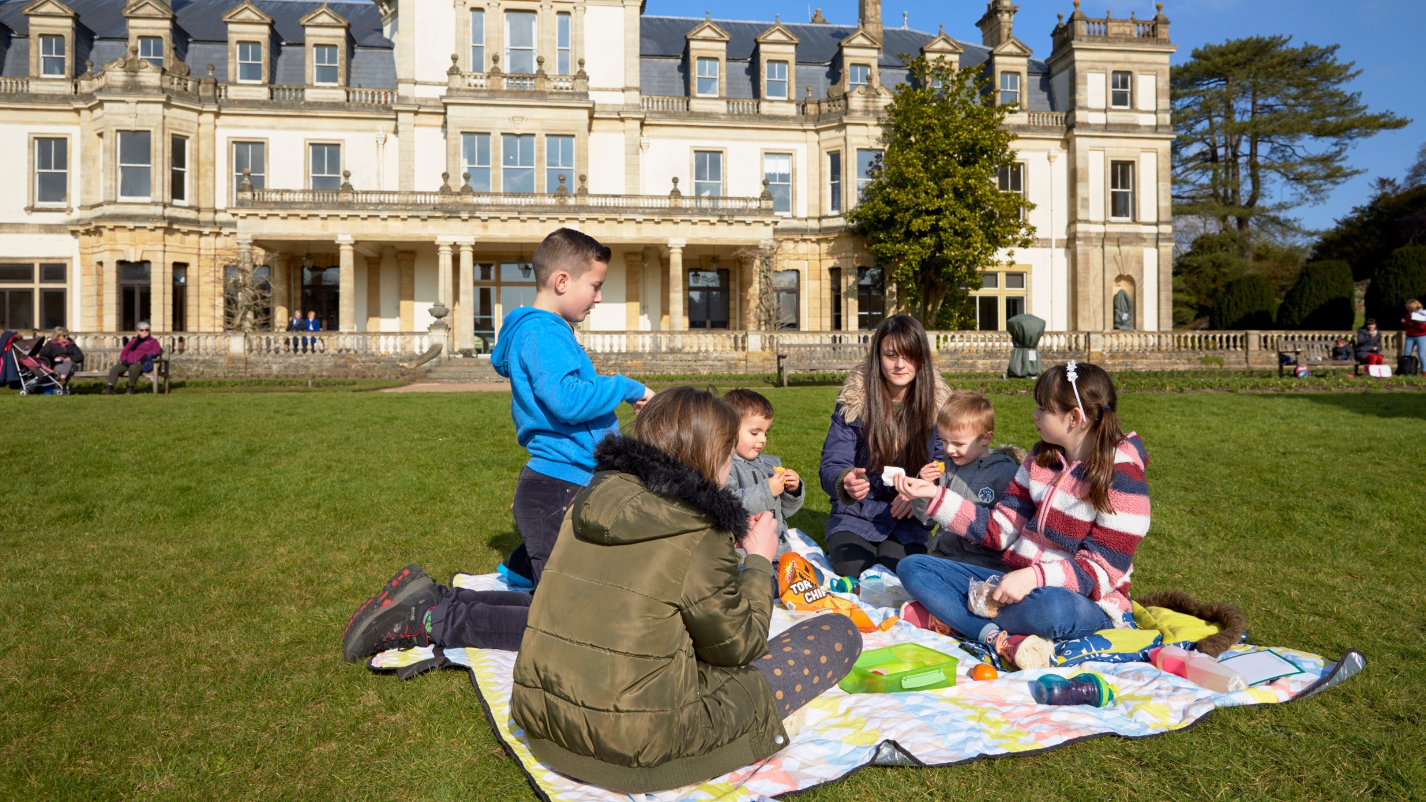 A family sets up a picnic on the lawn outside Dyffryn House and Gardens, Vale of Glamorgan