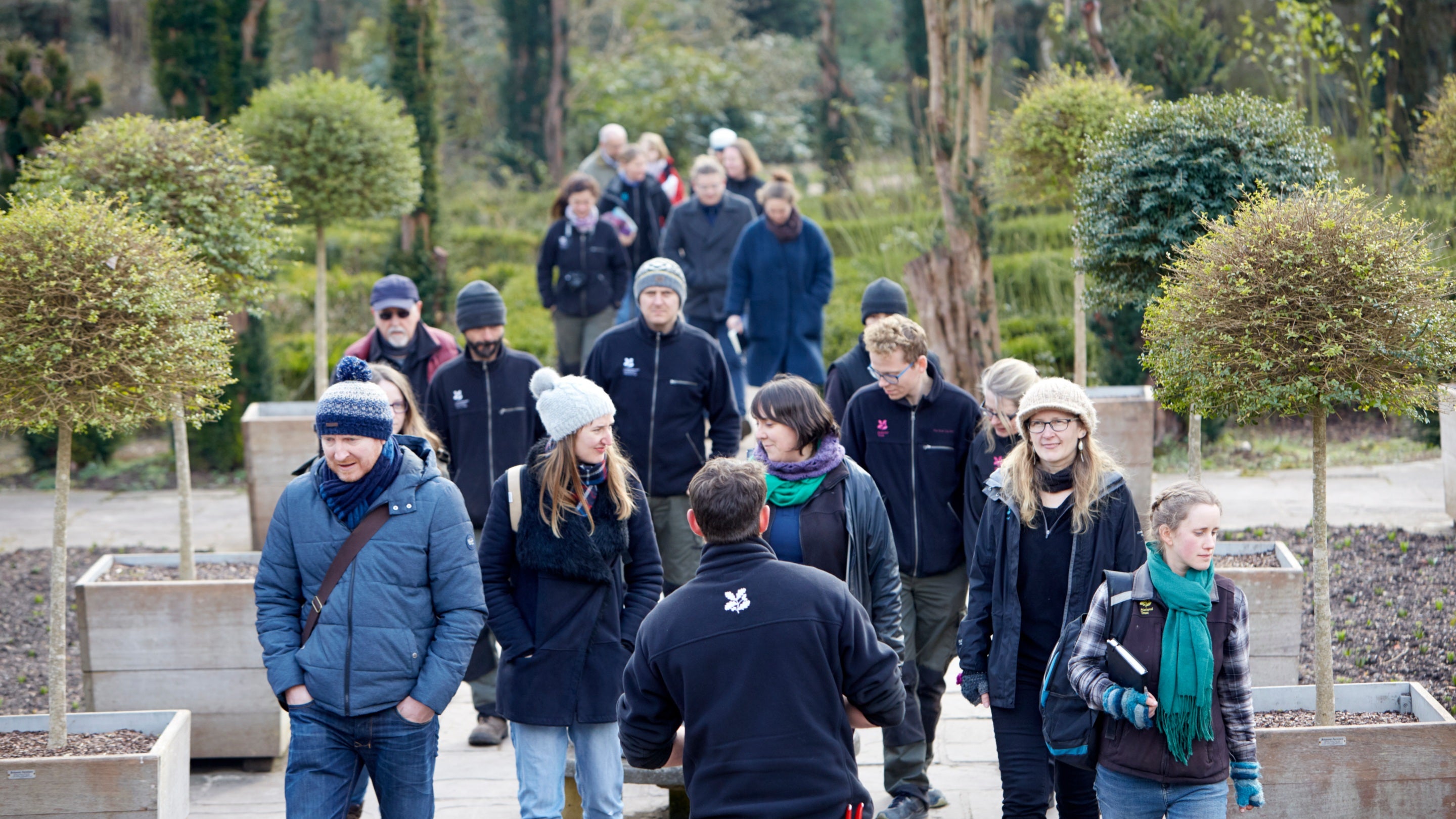 Grŵp o ymwelwyr ar daith o’r ardd yn y Cwrt Palmantog yng Ngerddi Dyffryn, Bro Morgannwg, Cymru