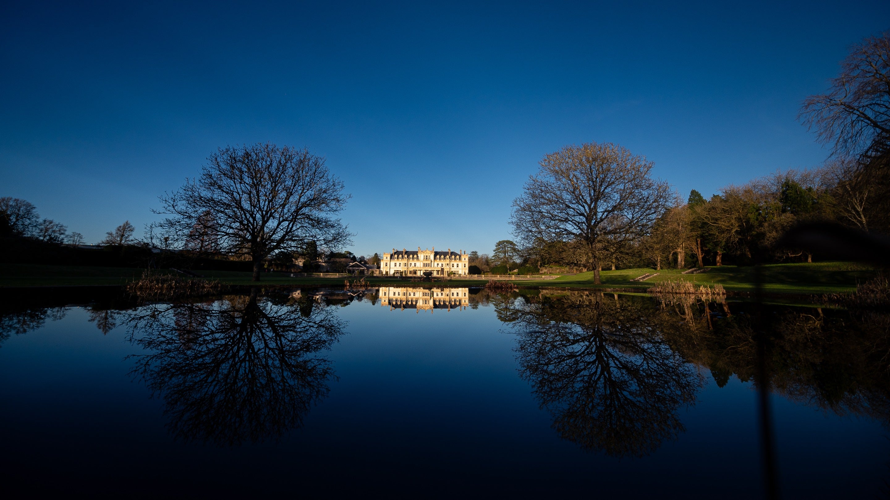 The reflection of the house in the still water of the Fountain Pool on a winter visit to Dyffryn Gardens, Vale of Glamorgan