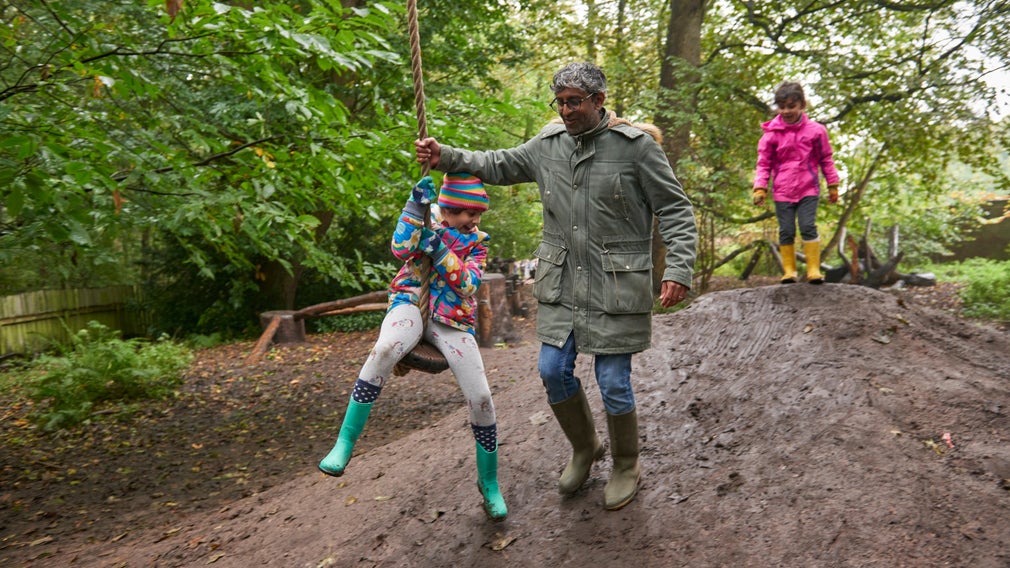 A family playing on a zipline in the natural play area at Erddig, Wrexham