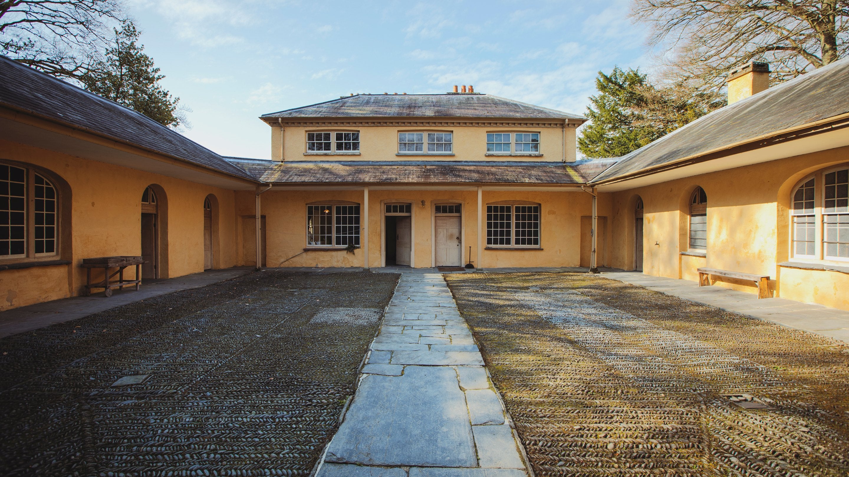 A square shaped courtyard surrounded by white walls with multiple doorways