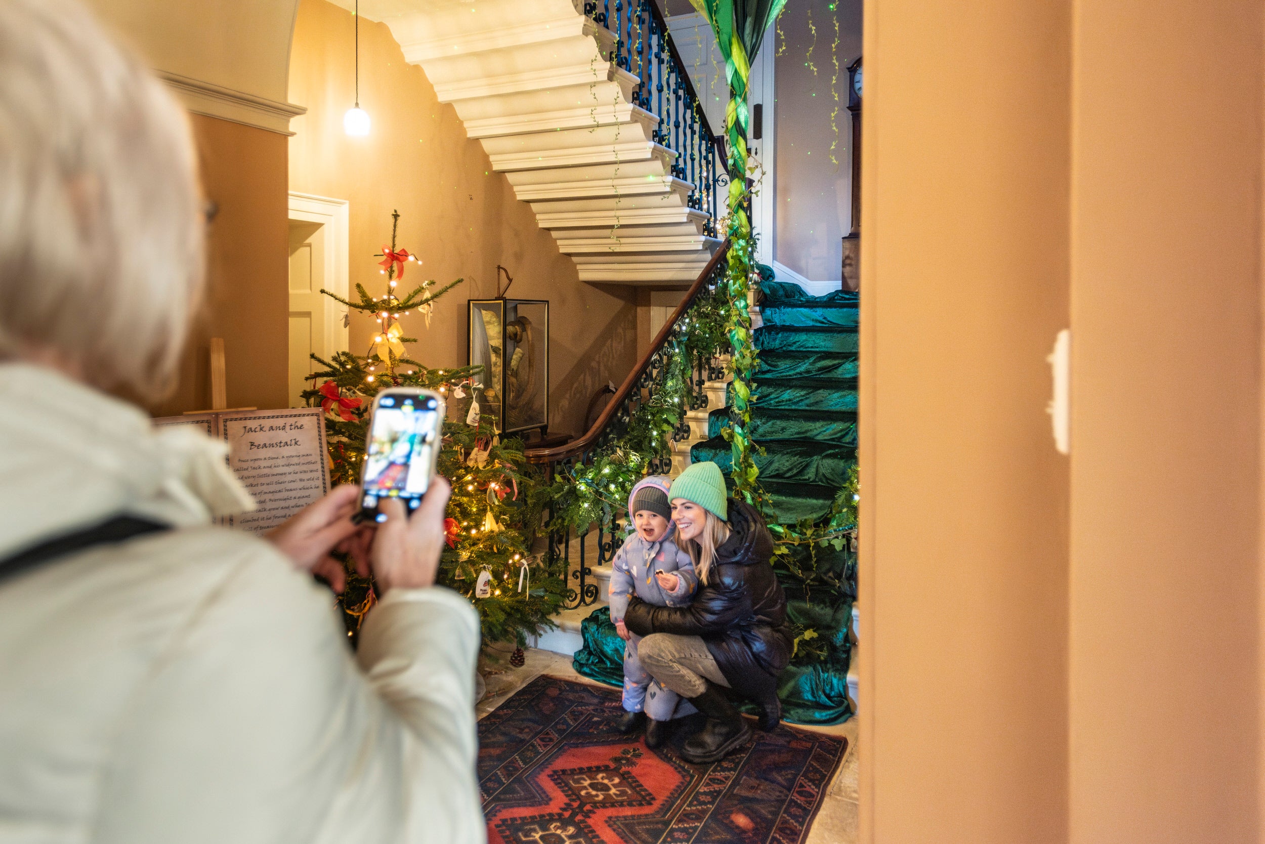 Mother and young child exploring the Christmas decorations at Llanerchaeron, Ceredigion