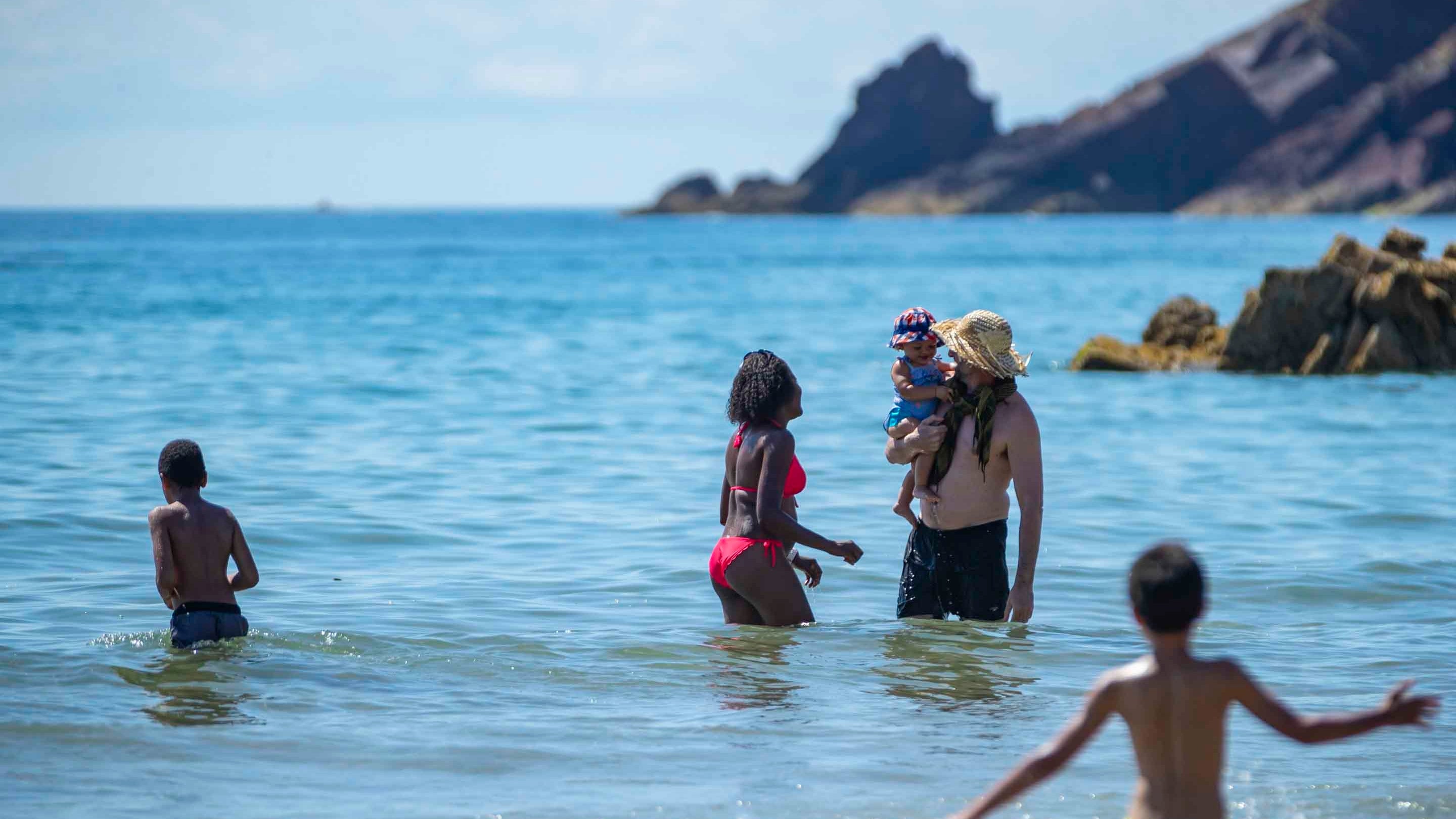 A family paddling in the sea at Marloes Sands, Pembrokeshire