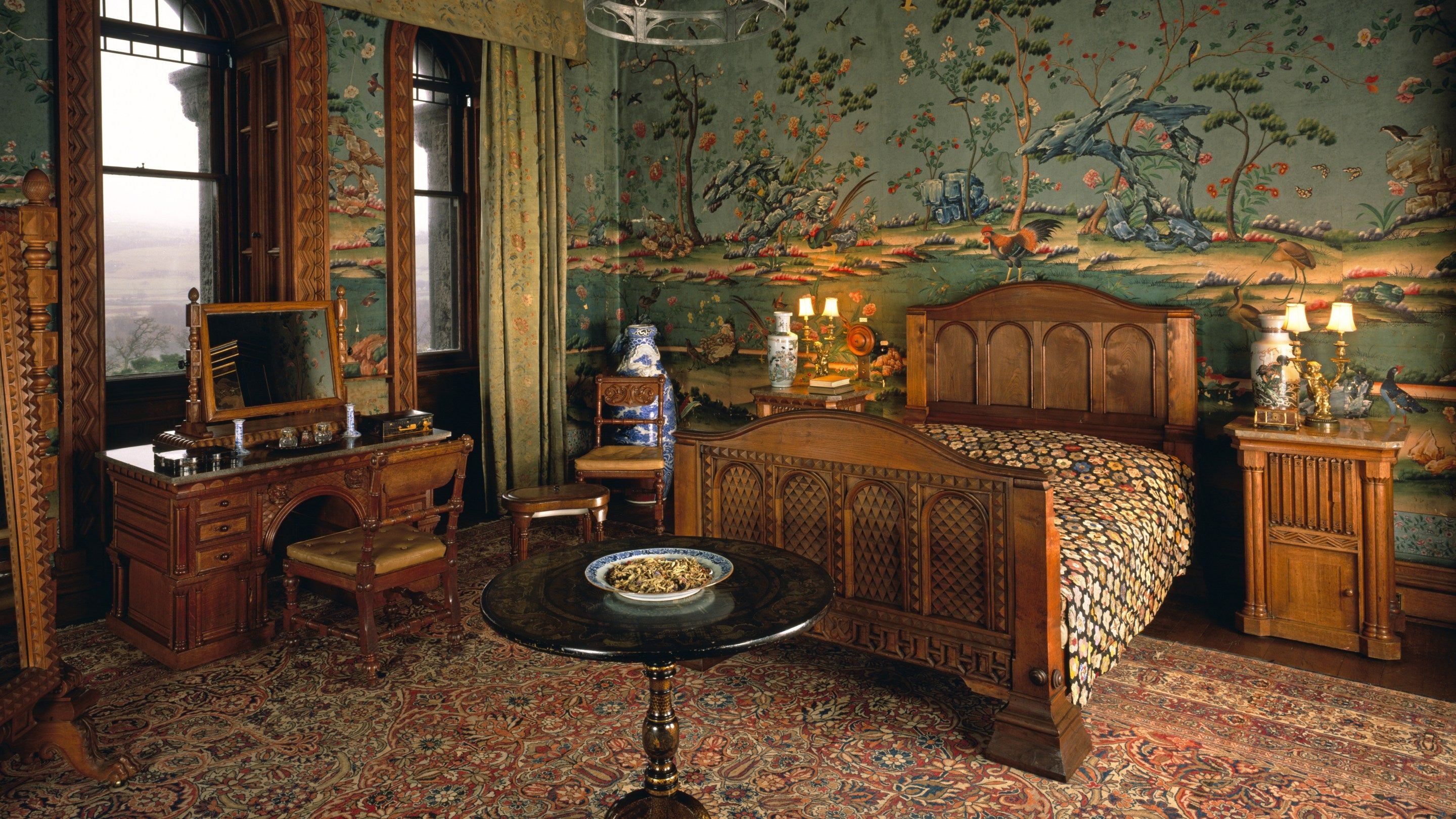 The Lower India Room at Penrhyn Castle, showing oak furniture including a bed, and Chinese wallpaper