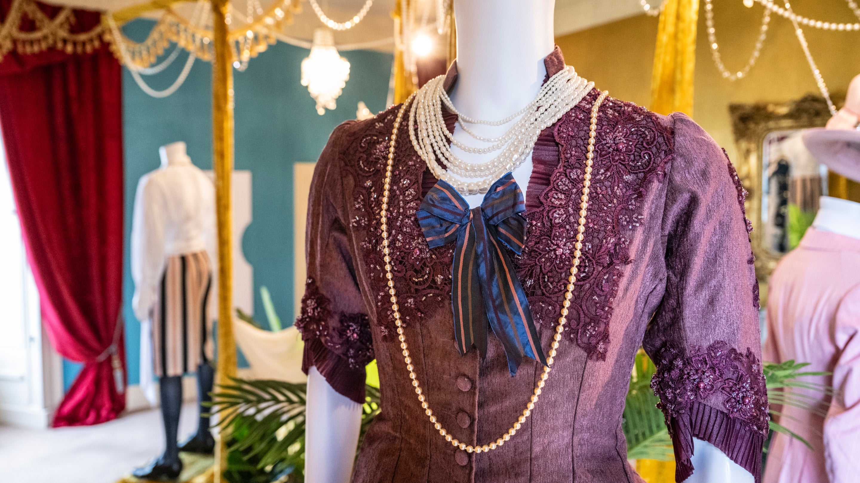 An elegant purple dress, with rows of pearls created for the film Madfabulous on display in the exhibition at Plas Newydd