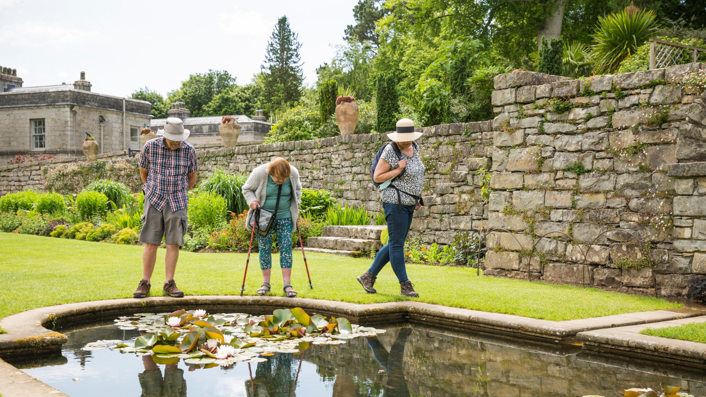 Visitors look at a pond on the Italianate terrace at Plas Newydd House and Gardens, Anglesey, Wales
