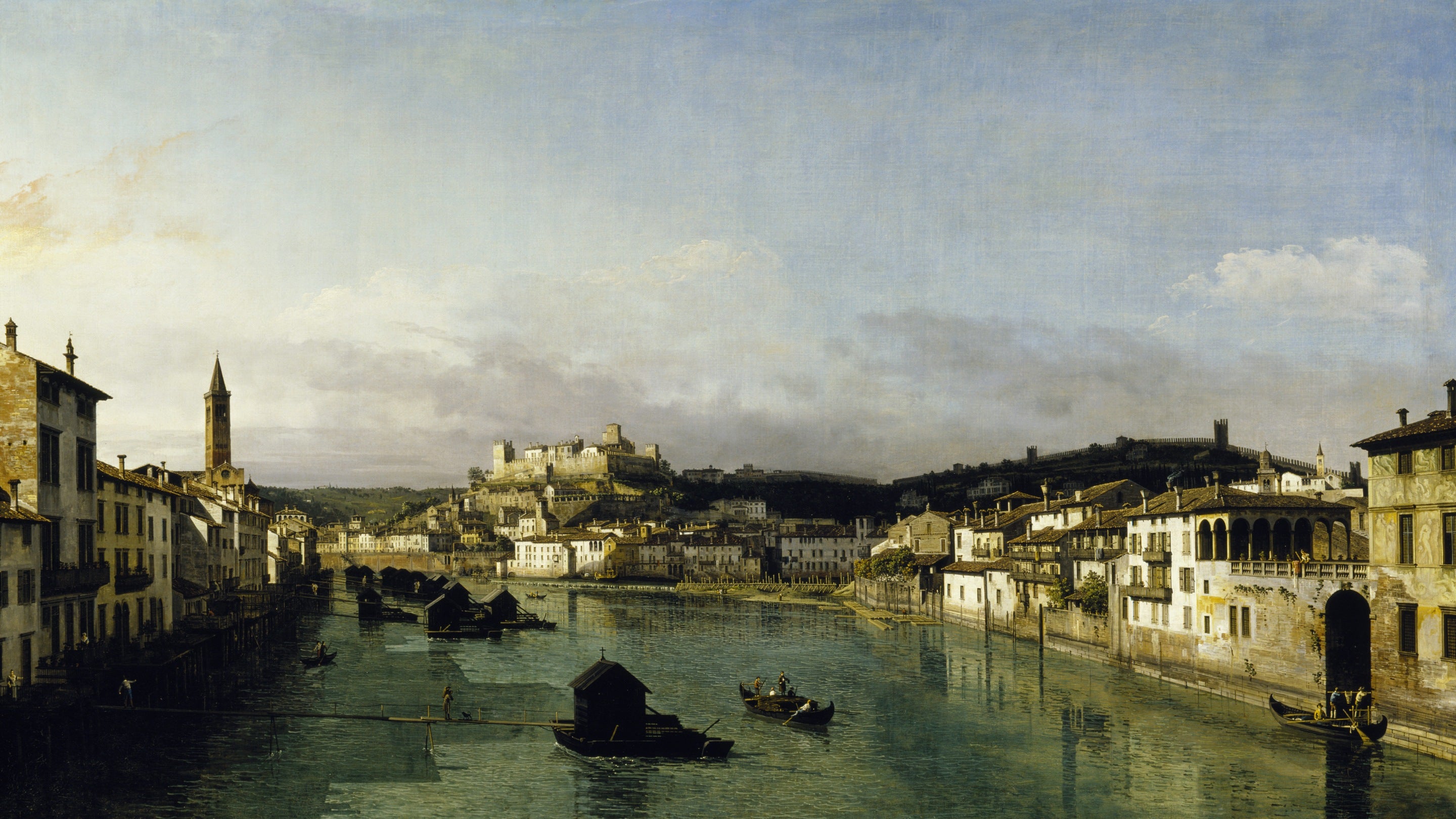 Oil painting of a View of Verona from the Ponte Nuovo by Bernardo Bellotto showing a wide canal surrounded by tall buildings with godolas on the water from 1745-47