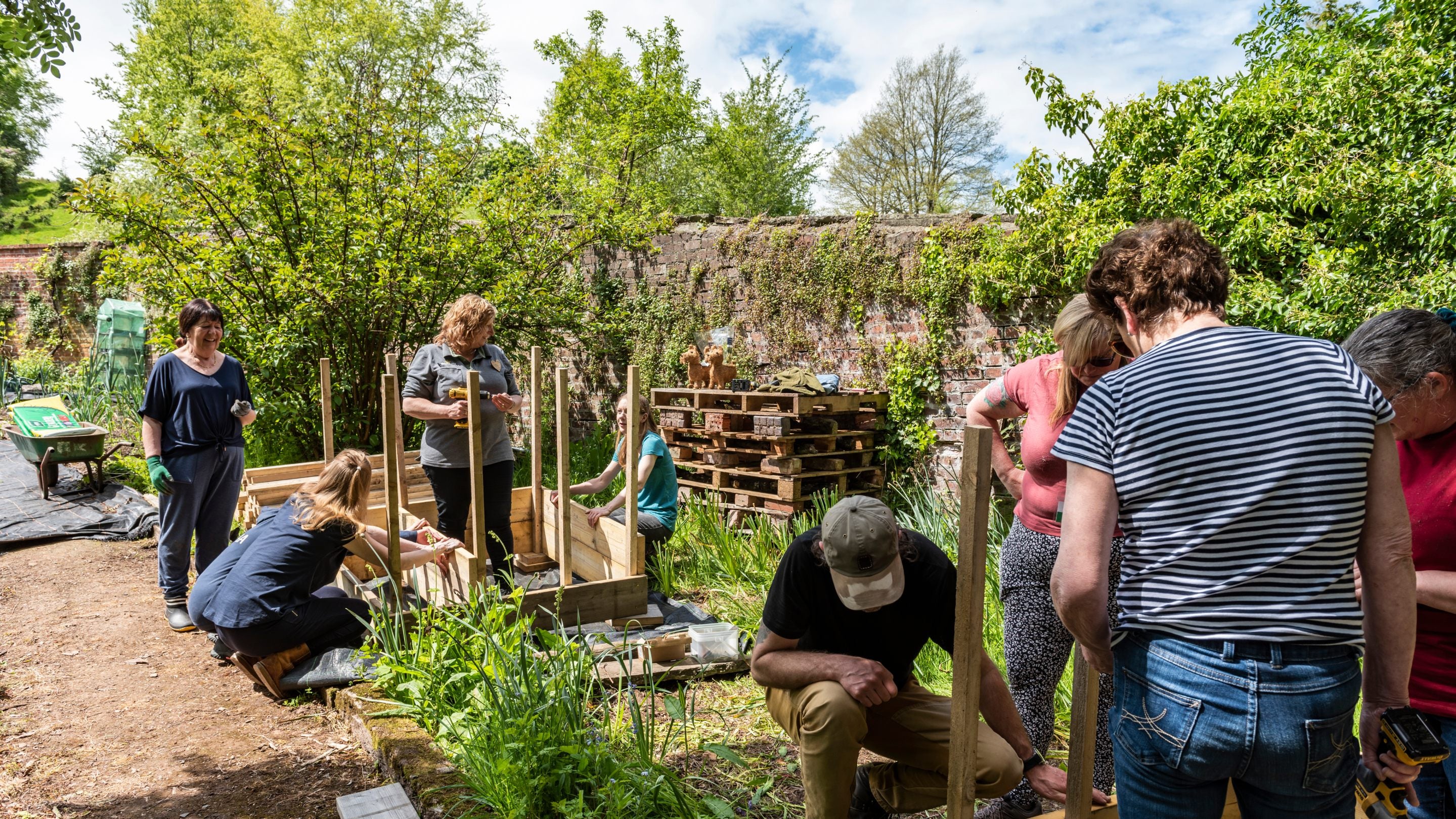 A group of people working to build a garden in the spring sunshine