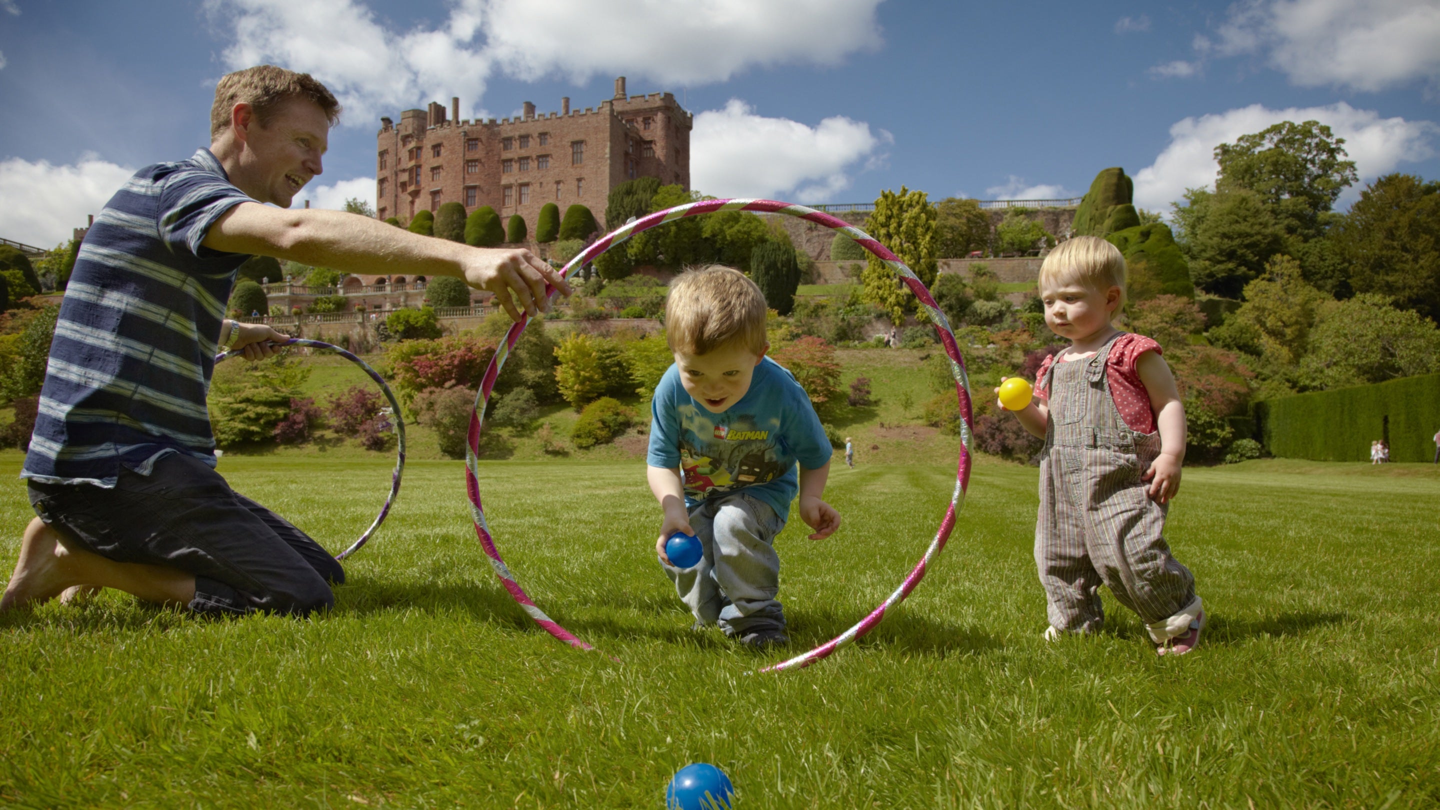 Family playing on the great lawn at Powis Castle on a sunny day in August in Wales.
