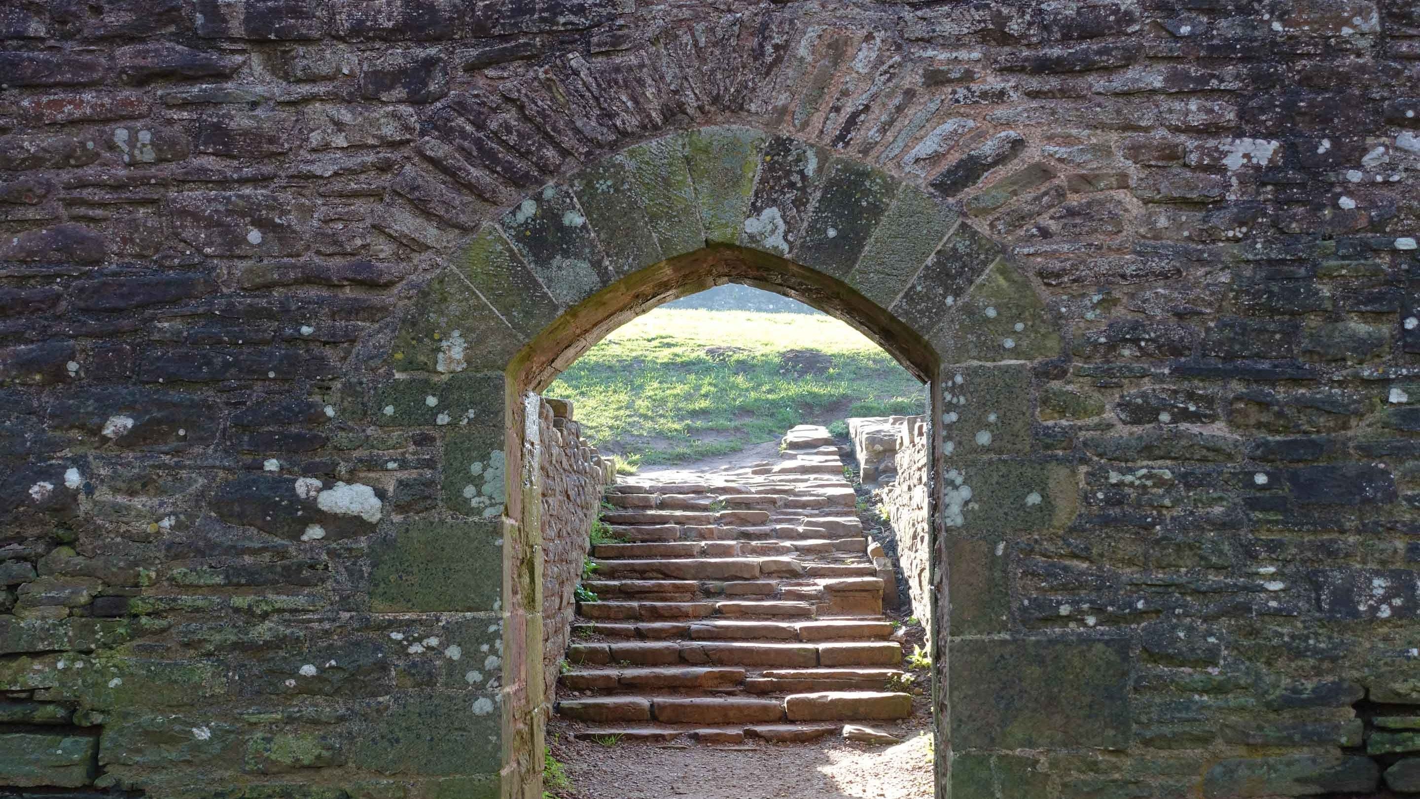 Golygfa drwy gât ddŵr fwaog i’r grisiau tu draw yng Nghastell Ynysgynwraidd