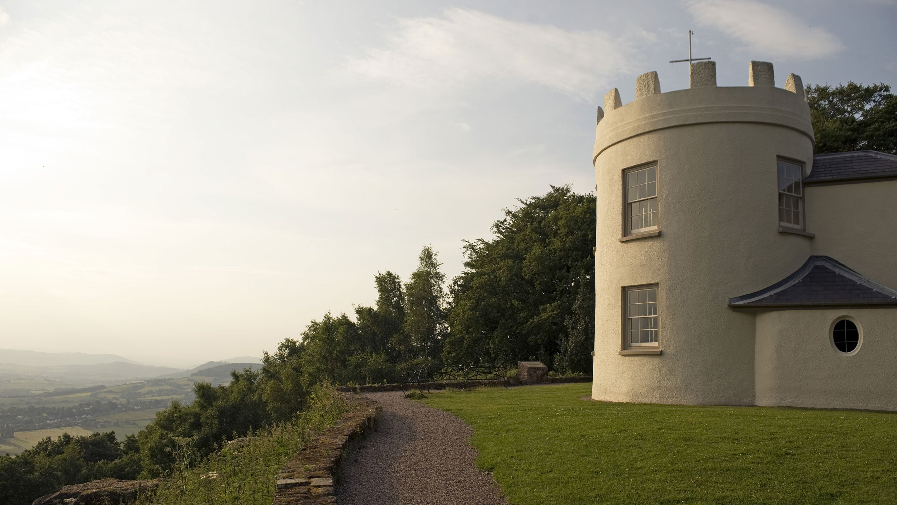 An exterior view of the the two-storey, circular, castellated Georgian banqueting house at the Kymin, the Monmouthshire countryside can be seen in the distance to the left of the picture.