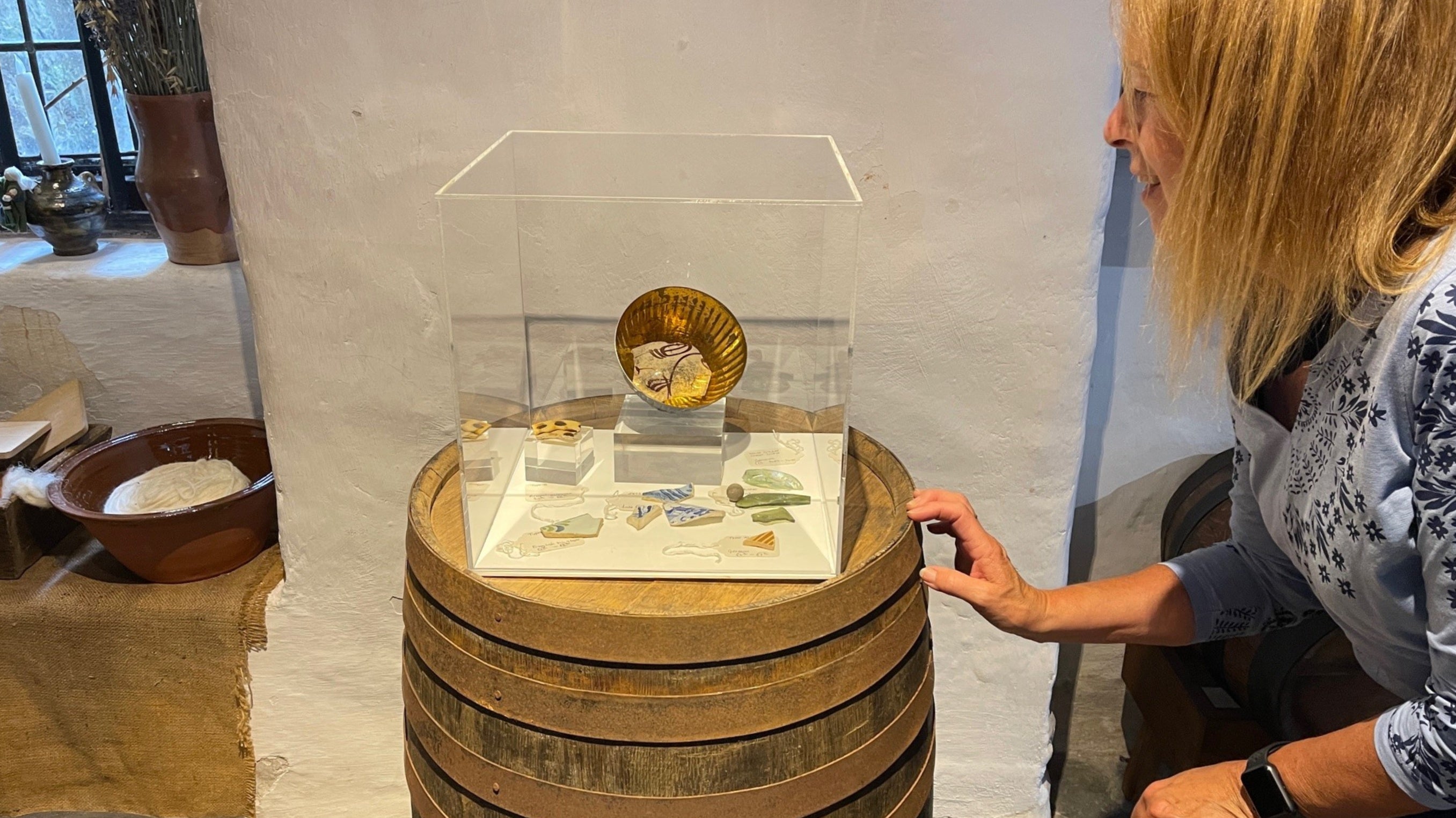 Visitor looking at pottery at the Tudor Merchants House Tenby