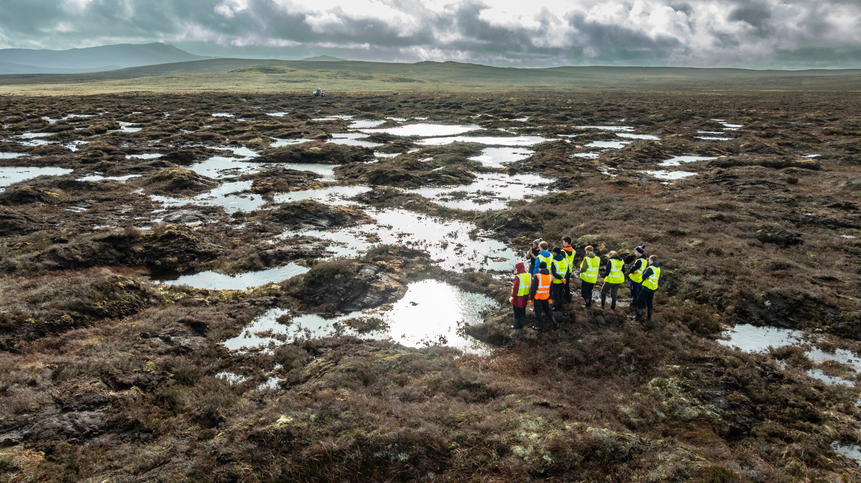 A group surveying a restored area of peatland on the Migneint plateau