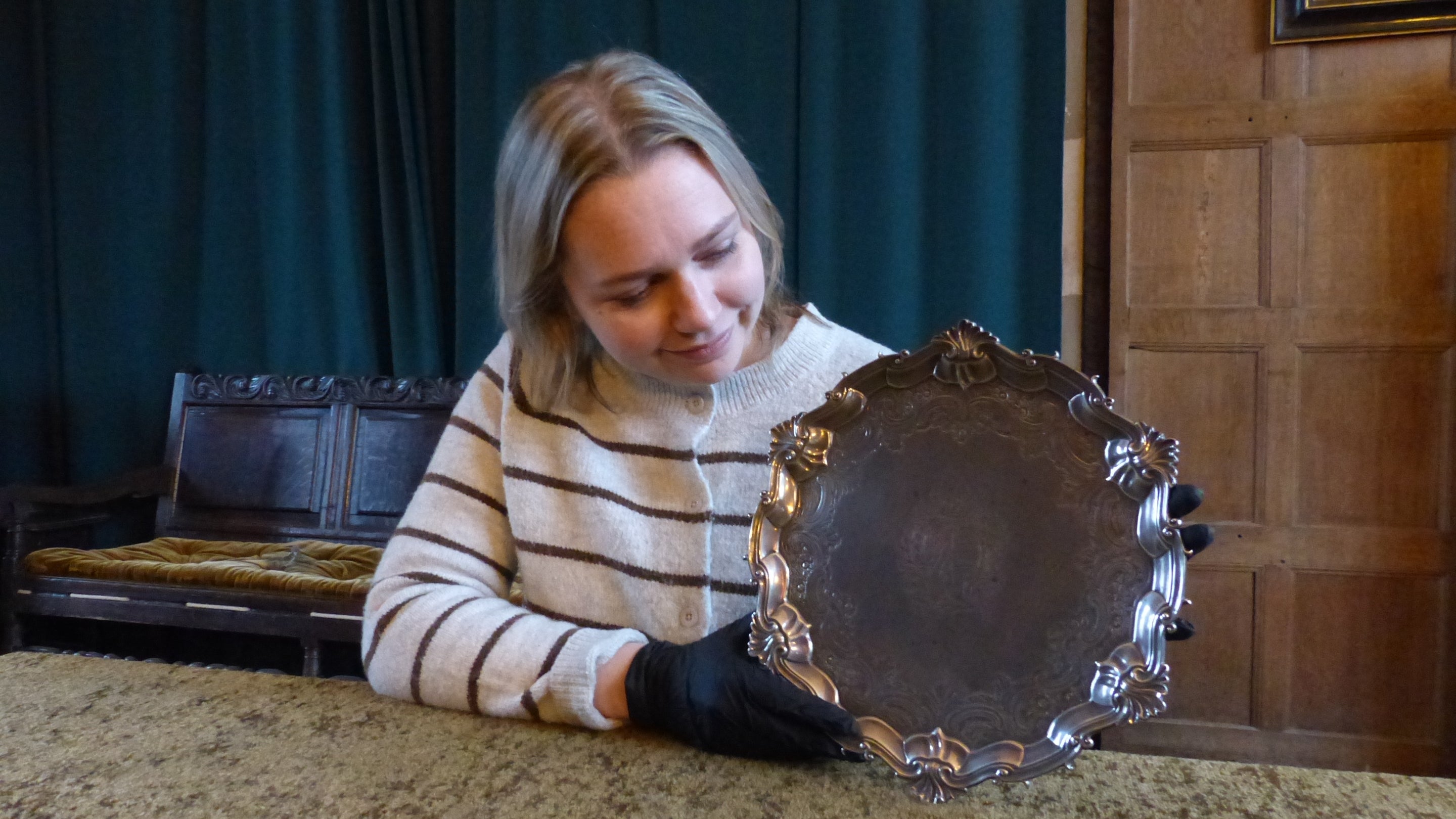 Emily Greaves, Collections and House Manager at Packwood House, holding the Mills Salver at Baddesley Clinton, Warwickshire