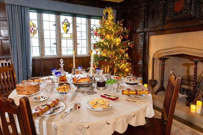 A view of the Dining Room at Baddesley Clinton, Warwickshire, with the table set for Christmas dinner