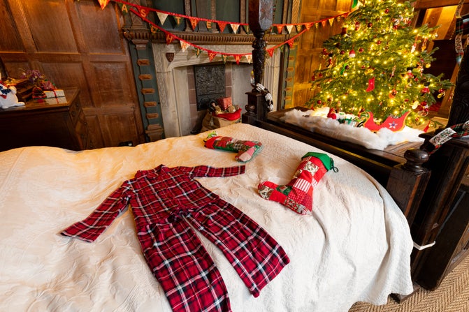On one of the beds a pair of pyjamas and some Christmas stockings are laid out ready for Santa